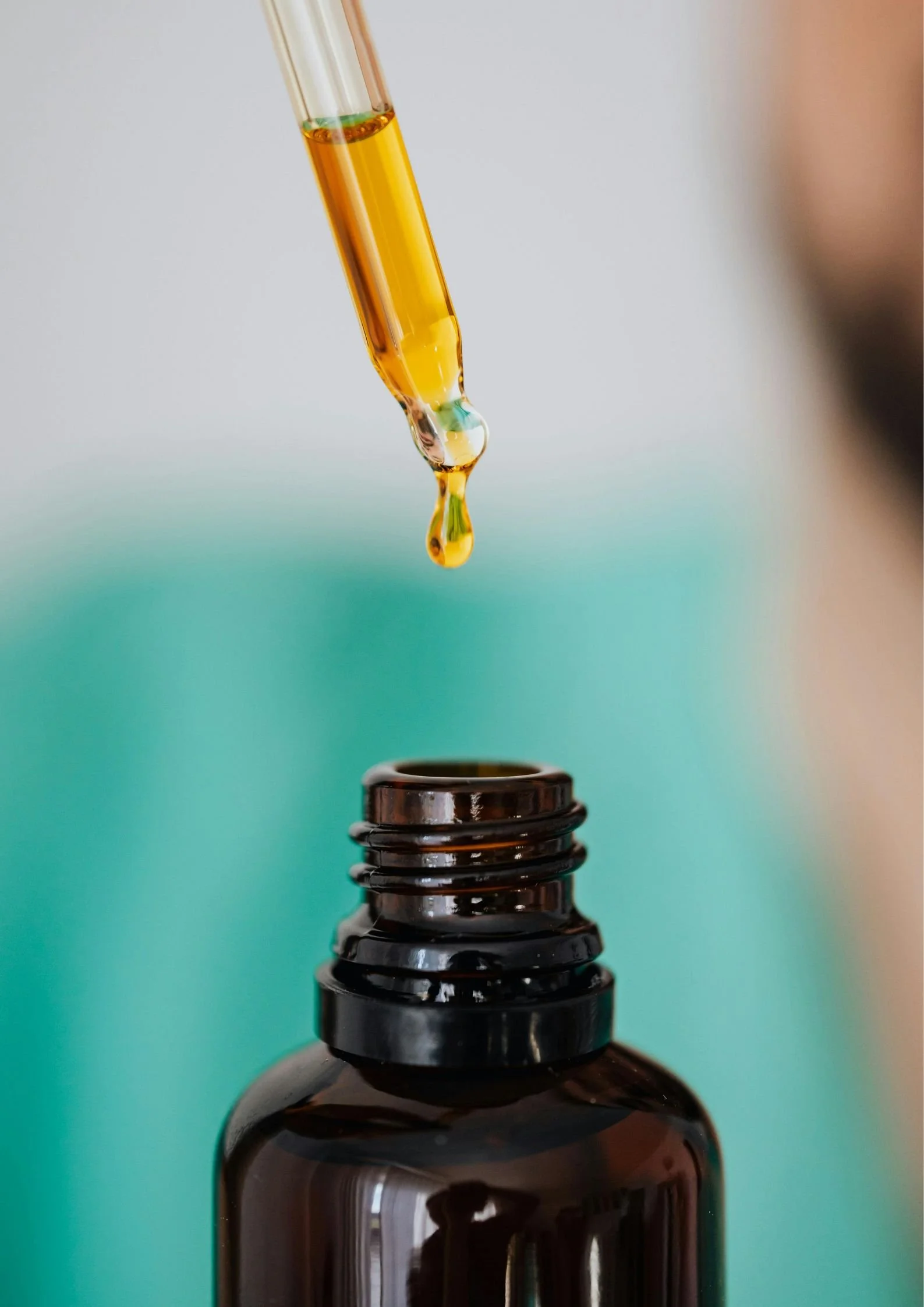 Goccia di olio essenziale che cade sulla boccetta