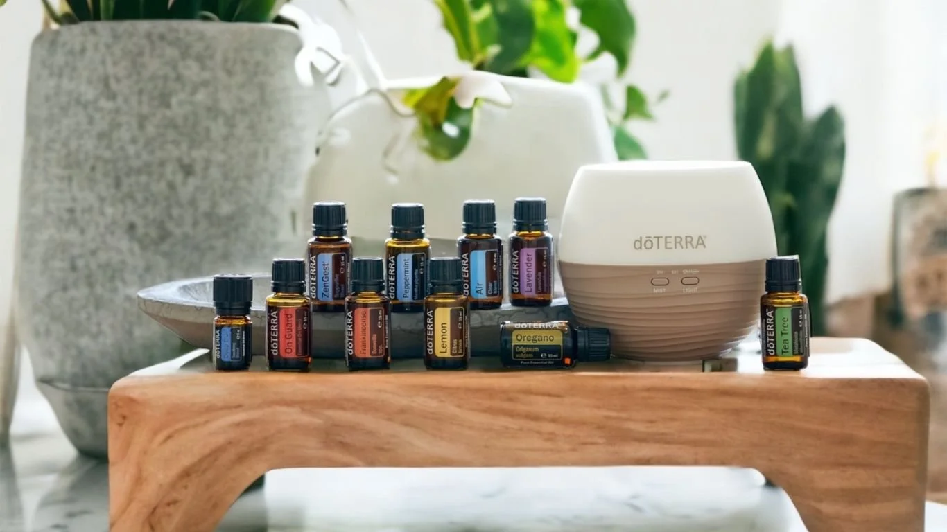 Home Essentials Kit doTERRA 10 boccette con diffusore su vassoio in legno e piante sullo sfondo