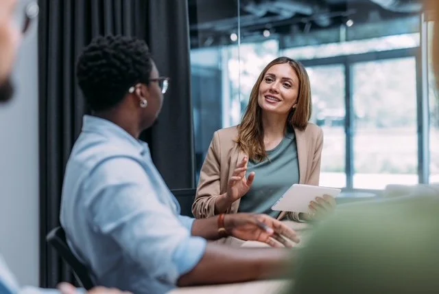 Two colleagues talking at a desk