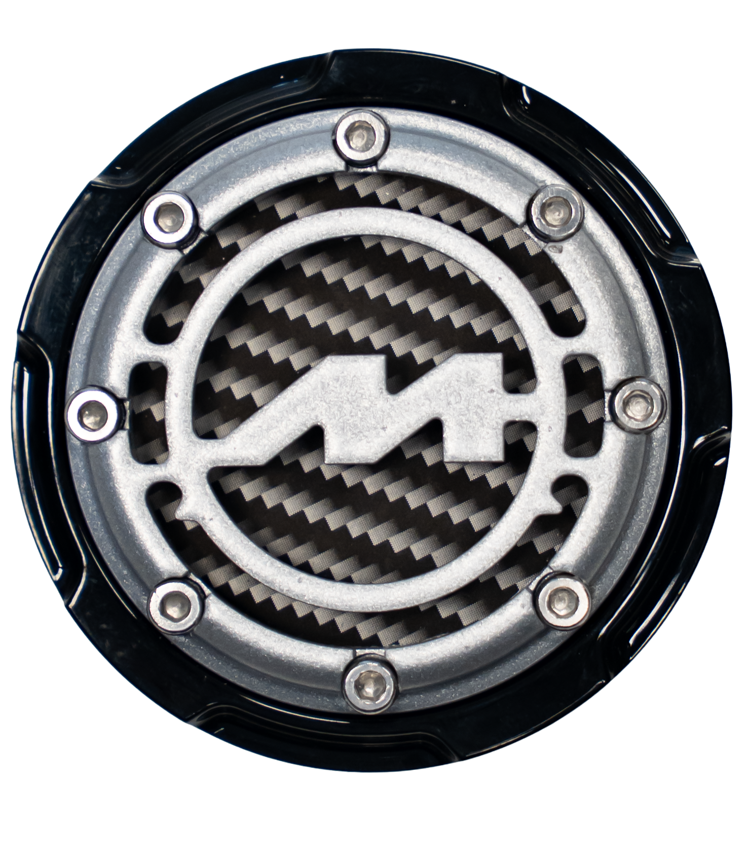 Close-up of a metallic Tesla logo cover with screws, mounted on a black circular frame, and a carbon fiber pattern background.