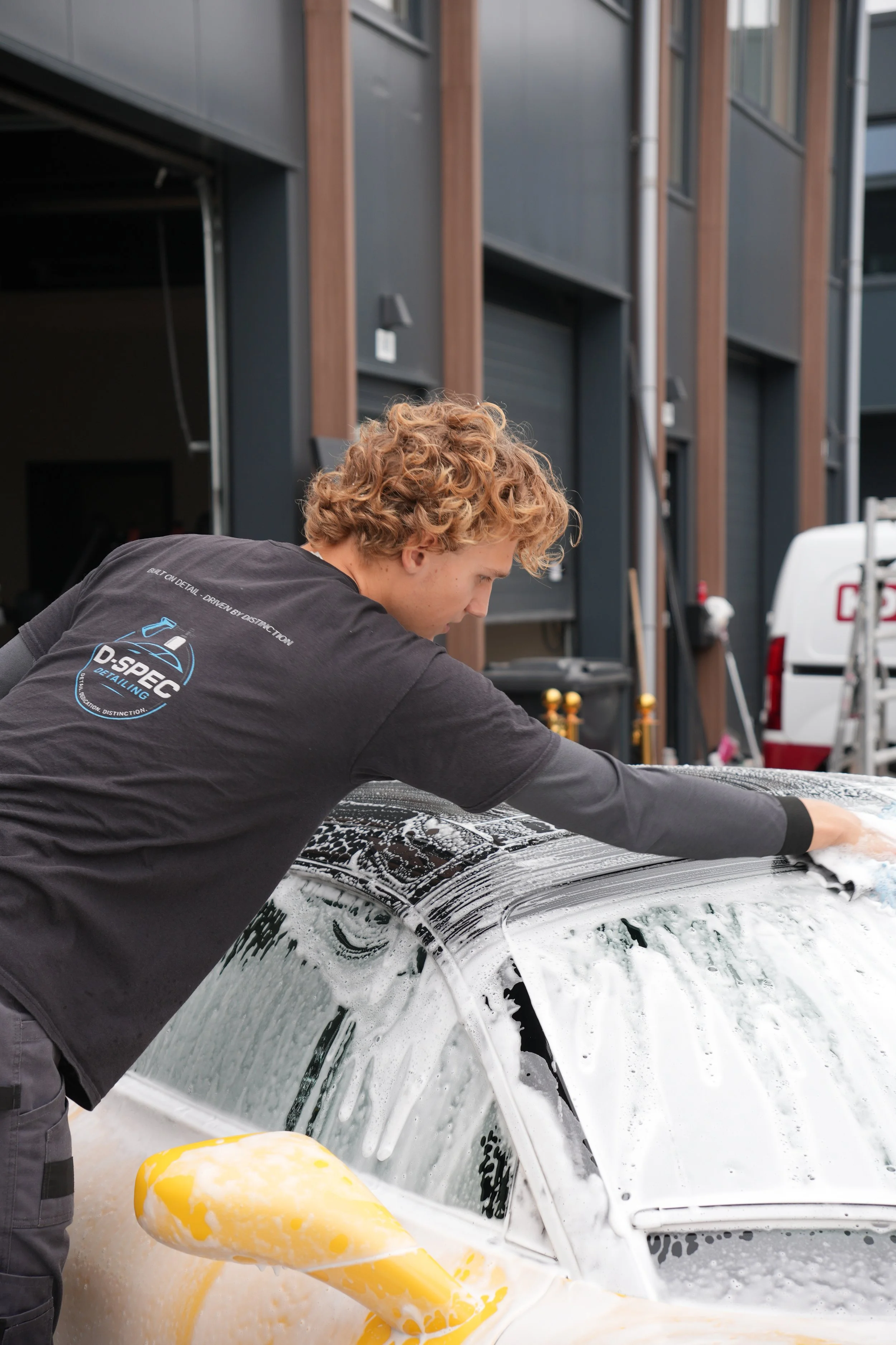 Een persoon die een Maserati MC20 professioneel aan het detailen is.