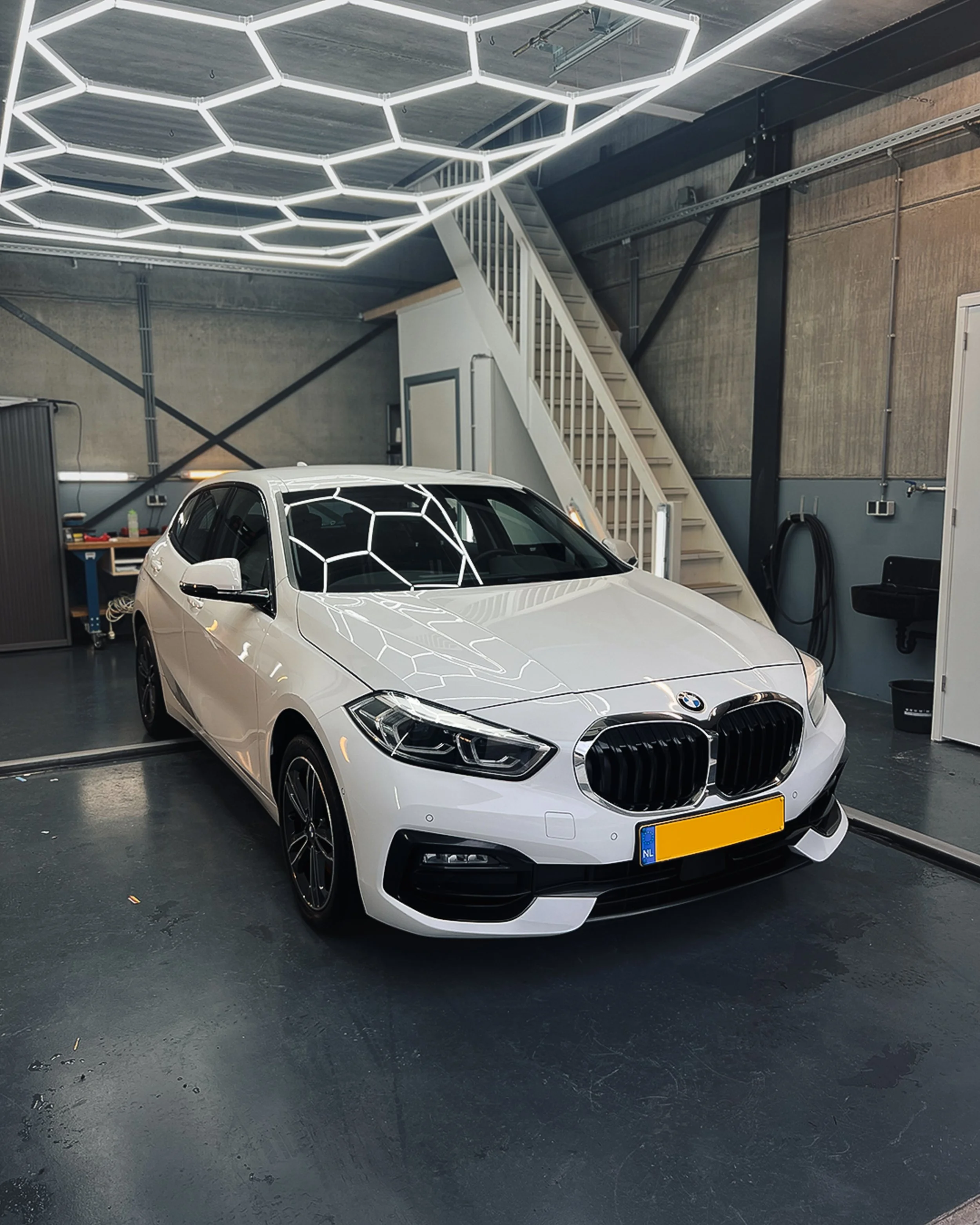 Een witte BMW 1-serie die professioneel is gedetaild