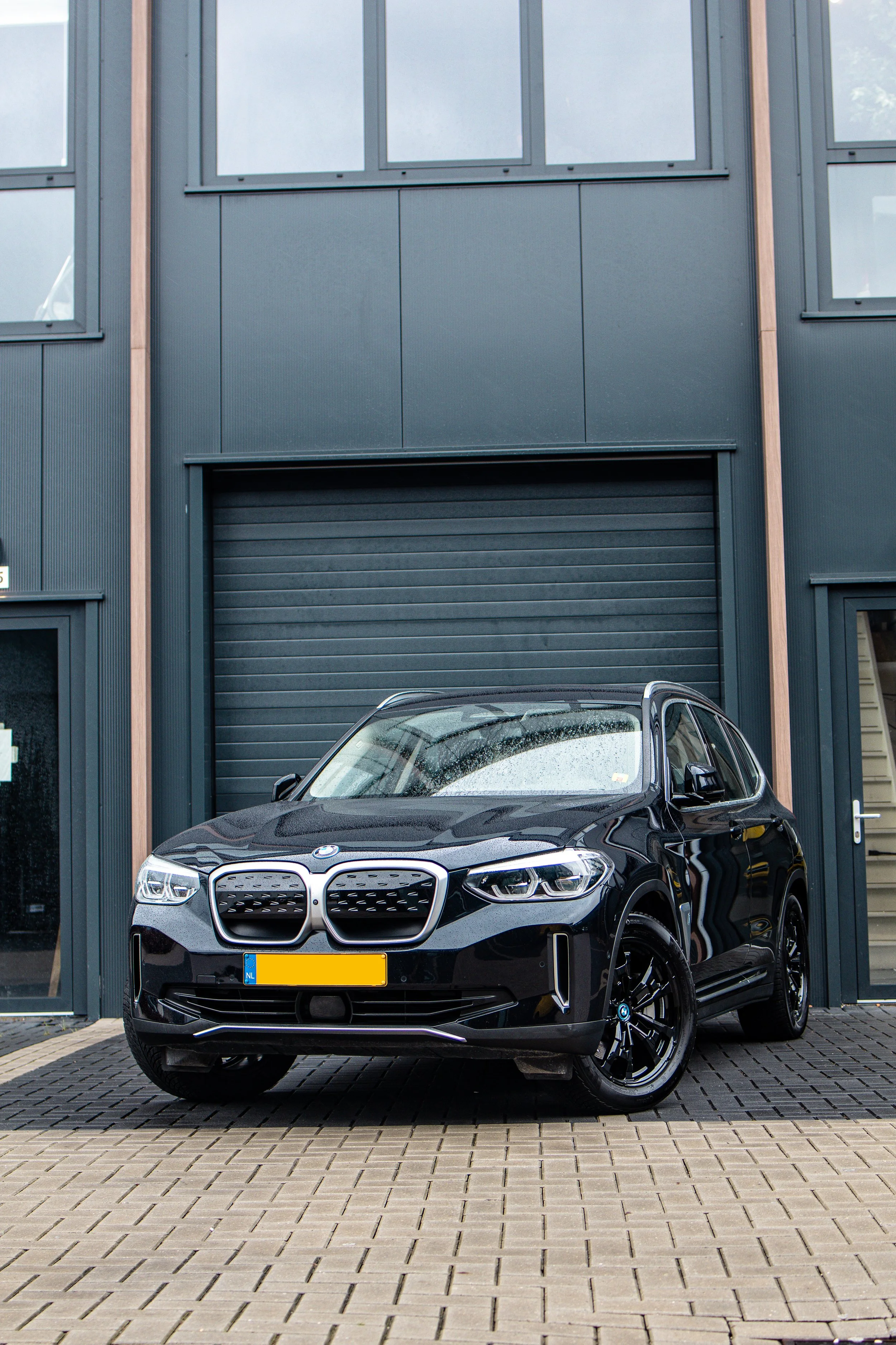 Een donkerblauwe BMW IX3 na het polijsten met een spiegelende la.