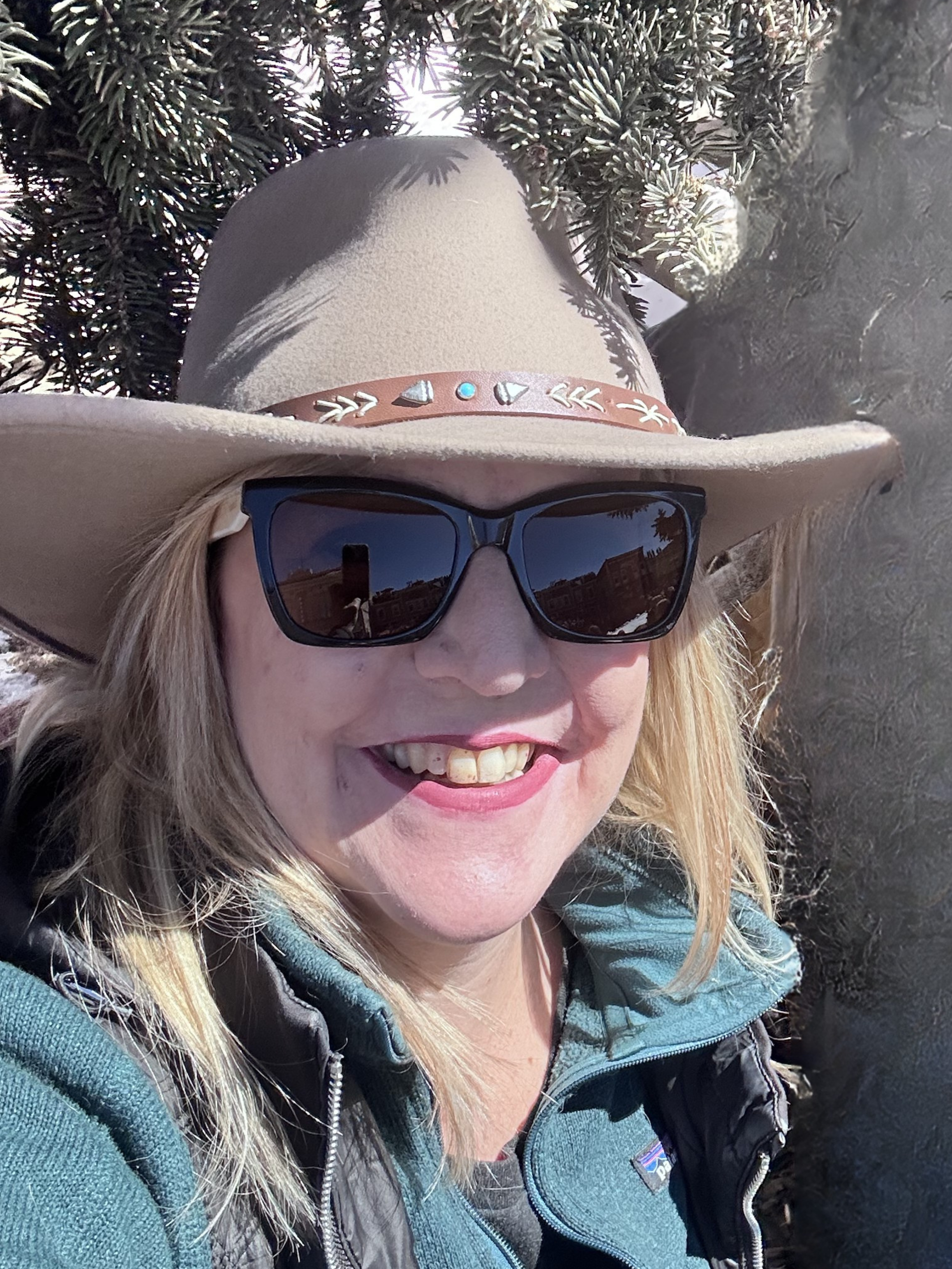 Woman in cowboy hat and sunglasses dressed in Western wear at Leadville Skijoring - what to wear to Colorado free winter event for first-timers