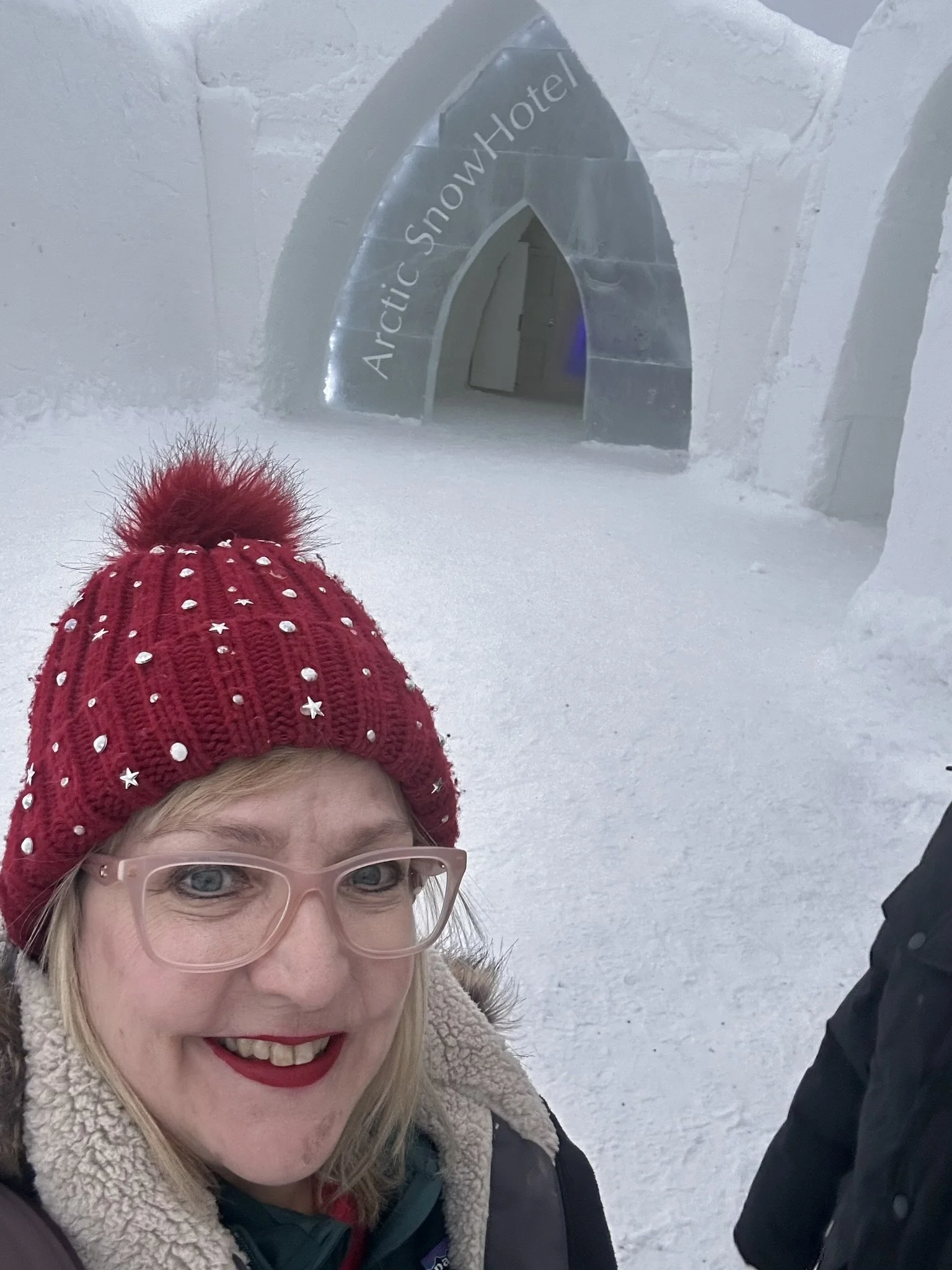 Traveler at Arctic SnowHotel carved ice entrance in Rovaniemi - real experience at Finland's iconic ice hotel