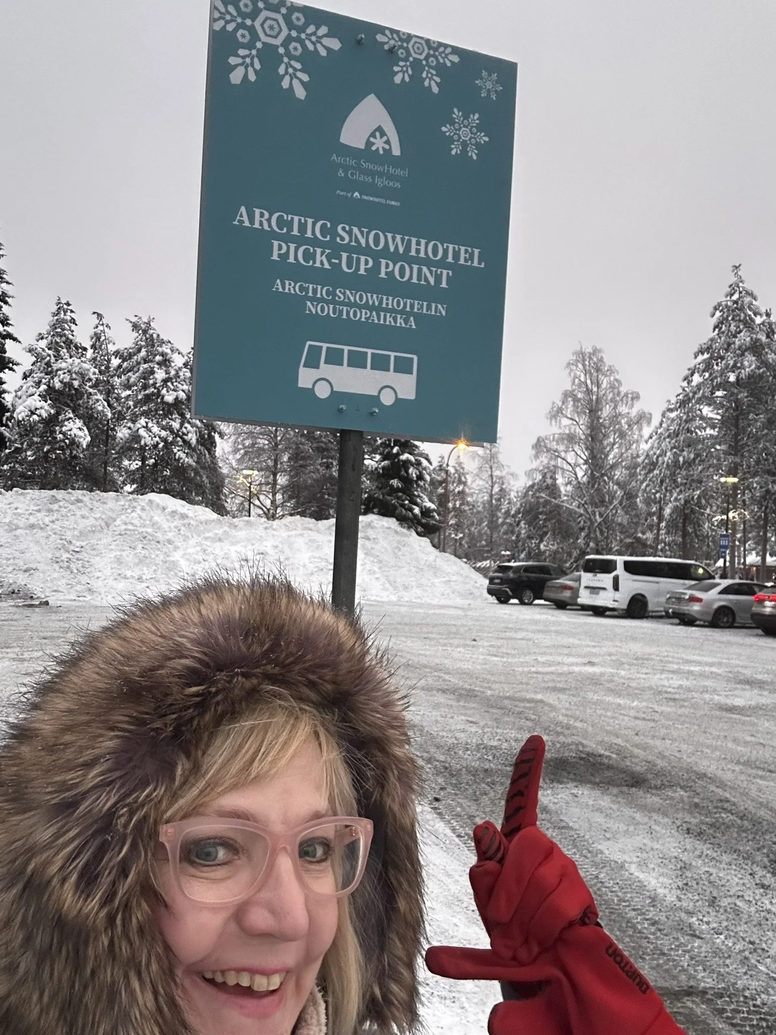 Excited traveler at Arctic SnowHotel pickup point in Rovaniemi, Finland - first-time winter adventure in Lapland