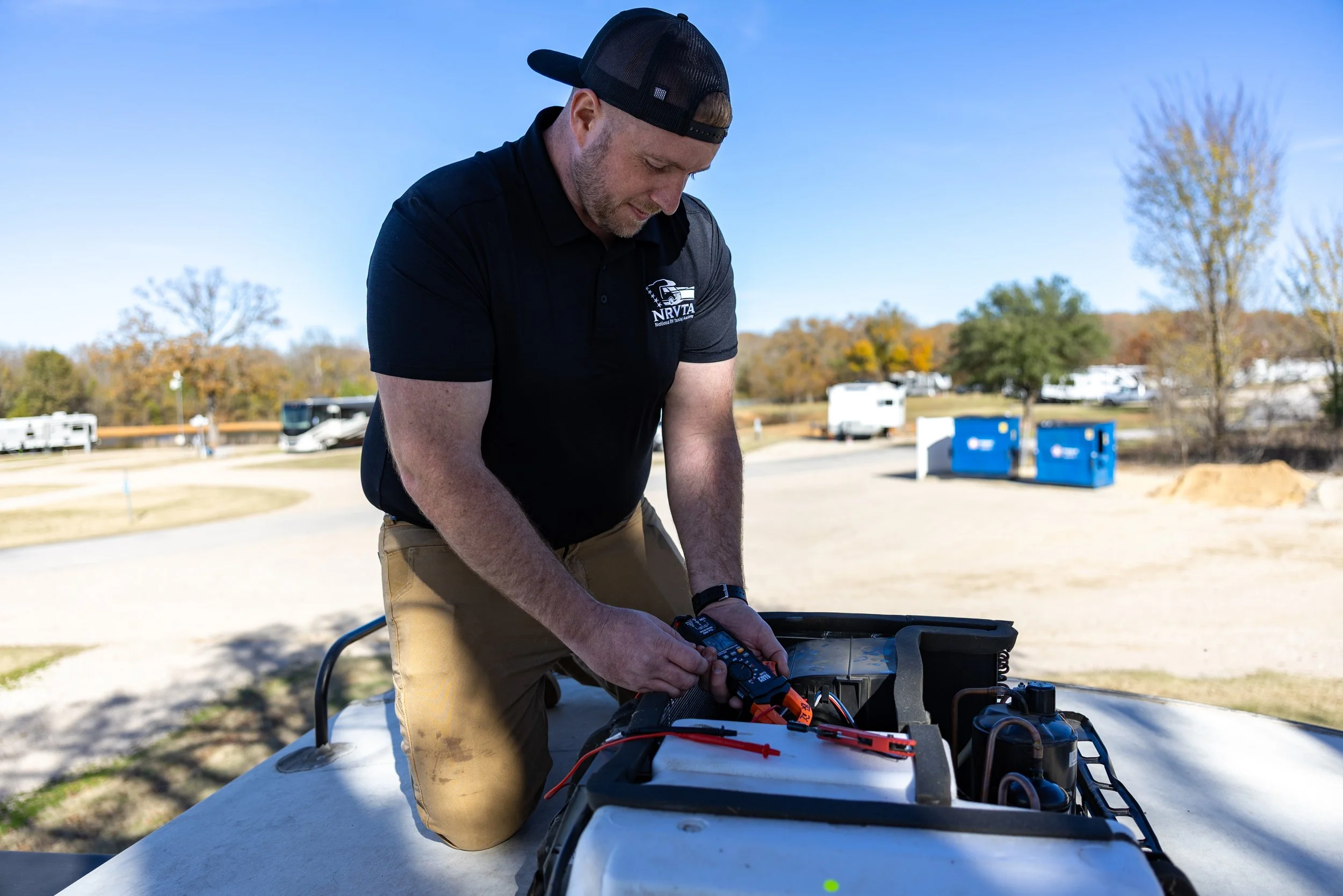 Man kneeling performing diagnosis of RV A/C unit. Repair RV AC.