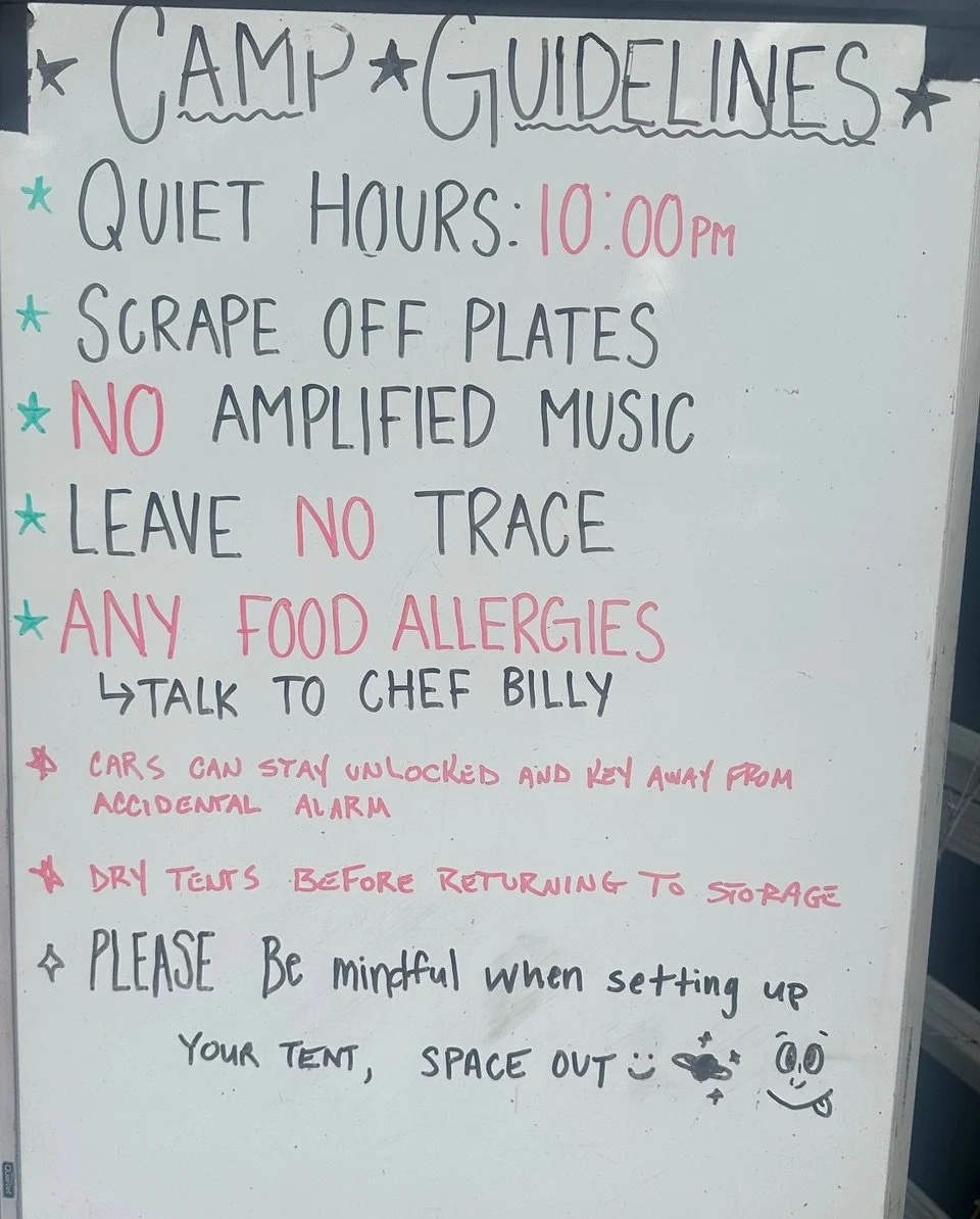 Whiteboard with camp guidelines written in black and pink marker