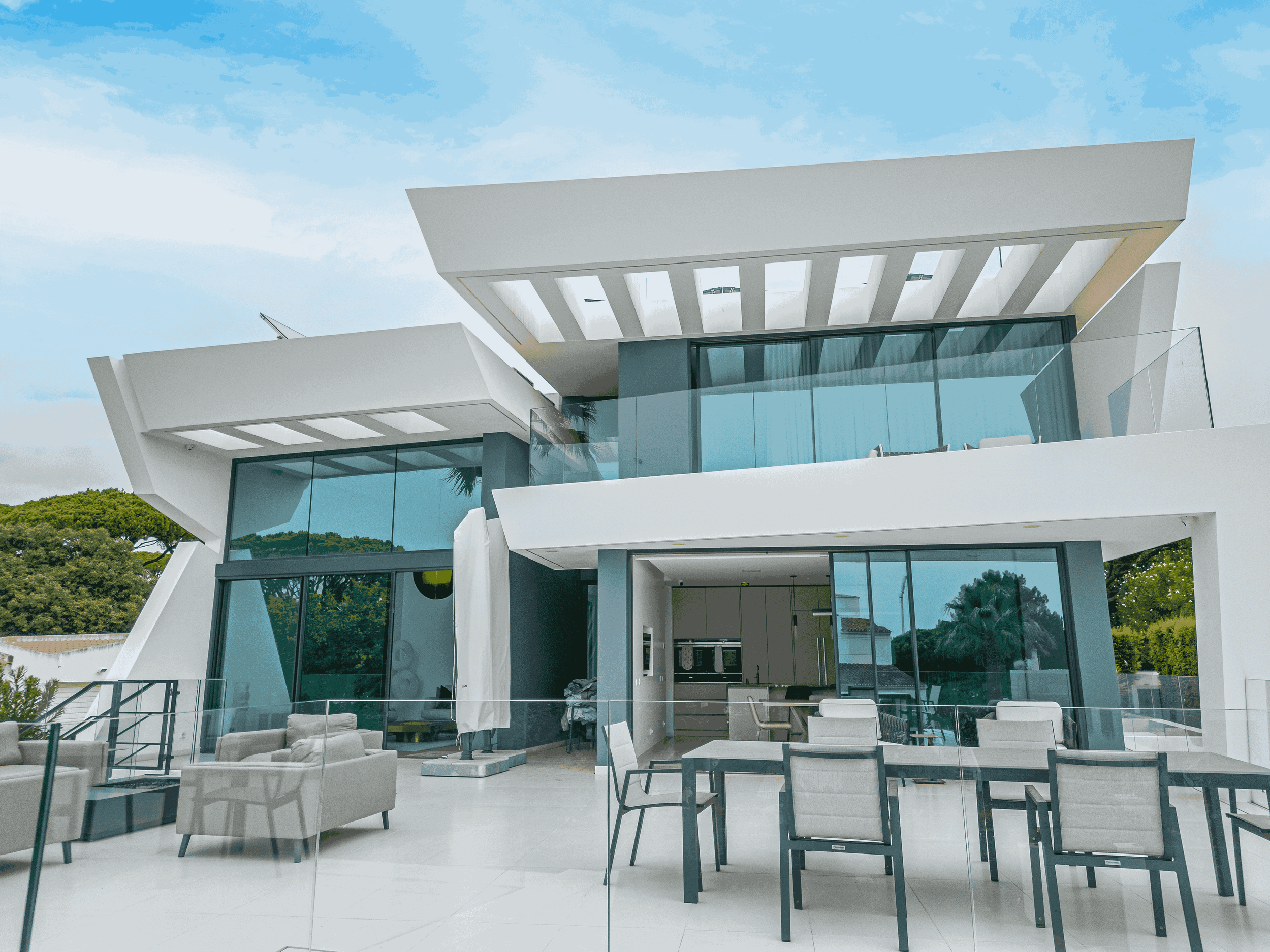 Residência moderna com janelas de vidro e varanda com móveis em espaço ao ar livre.