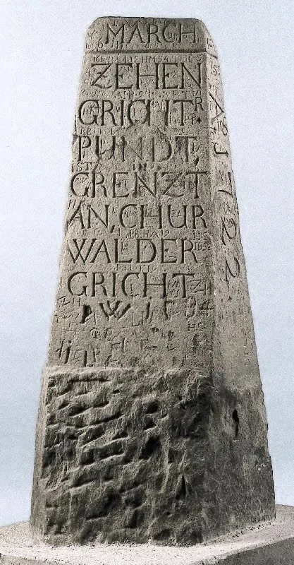 Grenzstein mit eingravierten Schriftzügen, historisch.  Calma Grischun, Kein Windpark, Windpark Nein, Dreibündenstein, Domleschg, Churwalden, Axpo.