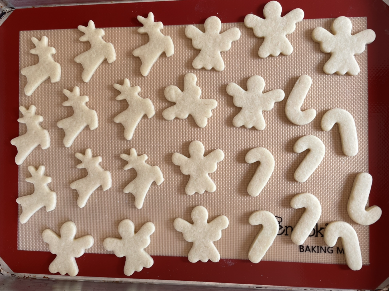 Unbaked reindeer, angels, and candy cane sugar cookie cut-outs for Christmas