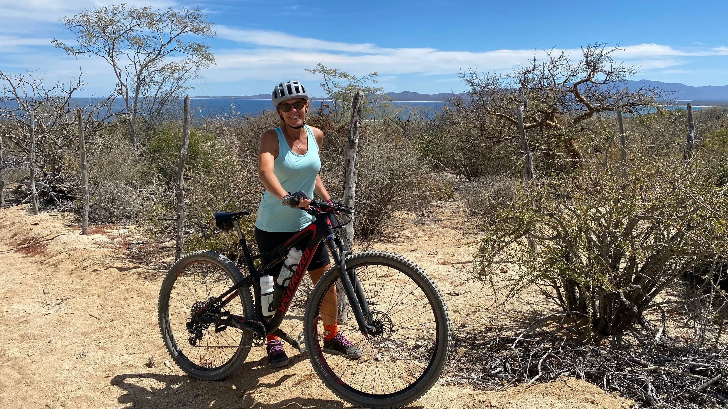 Brigid Greenwood walking her bike in Baja, Mexico.
