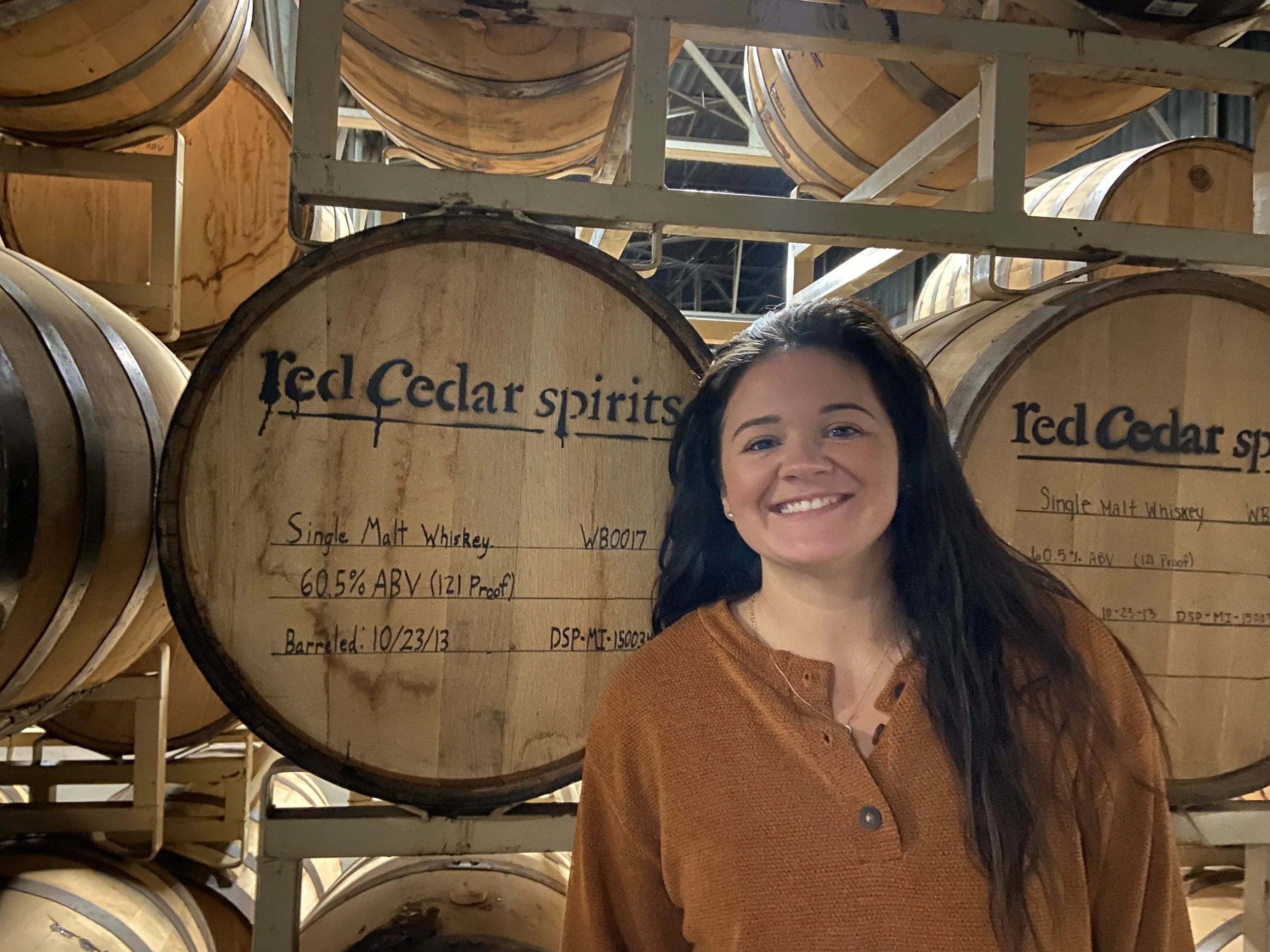 Dr. Nicole Shriner smiling in front of Single Malt Whiskey barrel