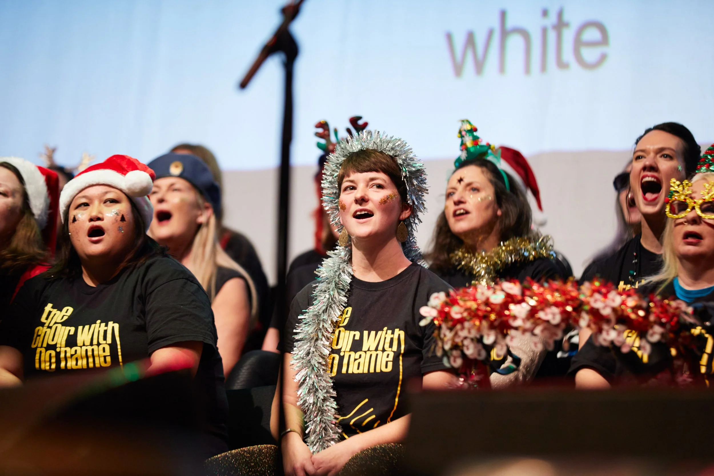 Choir With No Name Brighton performing on stage at their Christmas gig — one of the charity partners Soul of the City Choir supports.