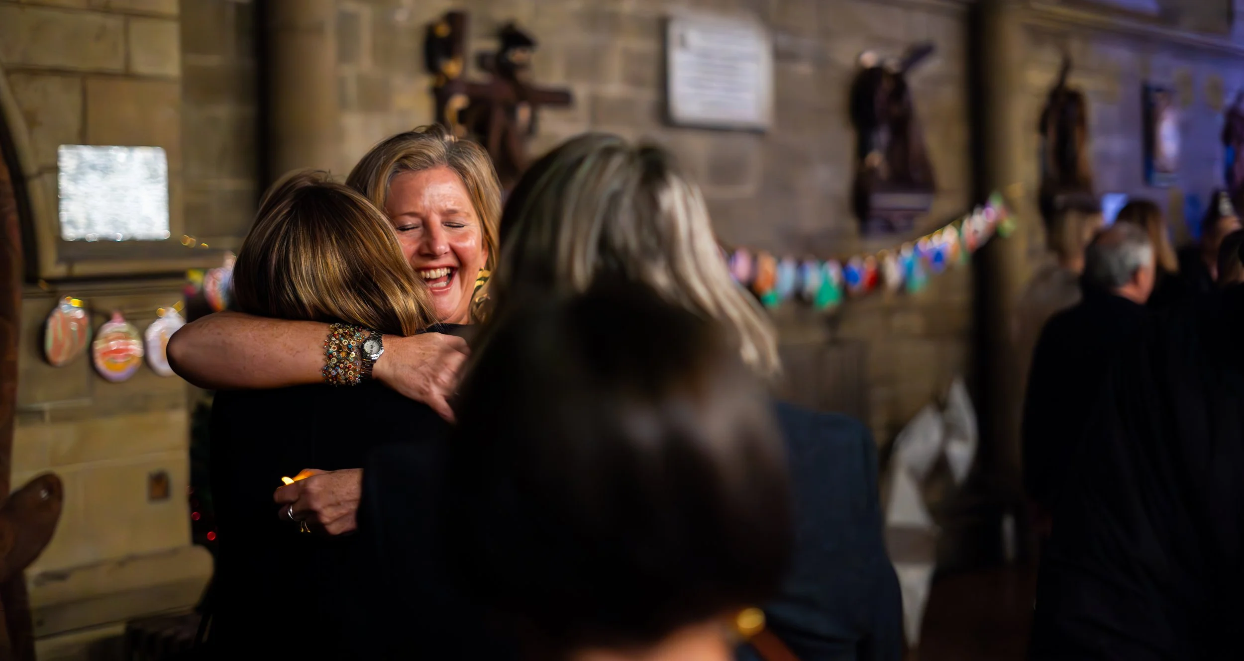 Two Soul of the City Choir members hugging and smiling, happy to see each other.