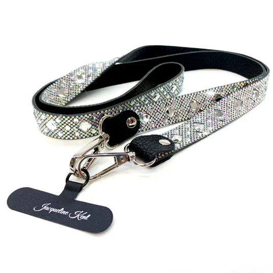 A dog collar with a rhinestone-encrusted strap, black leather accents, and a metal clasp, along with a black tag engraved with the name 'Jacquira Ant.