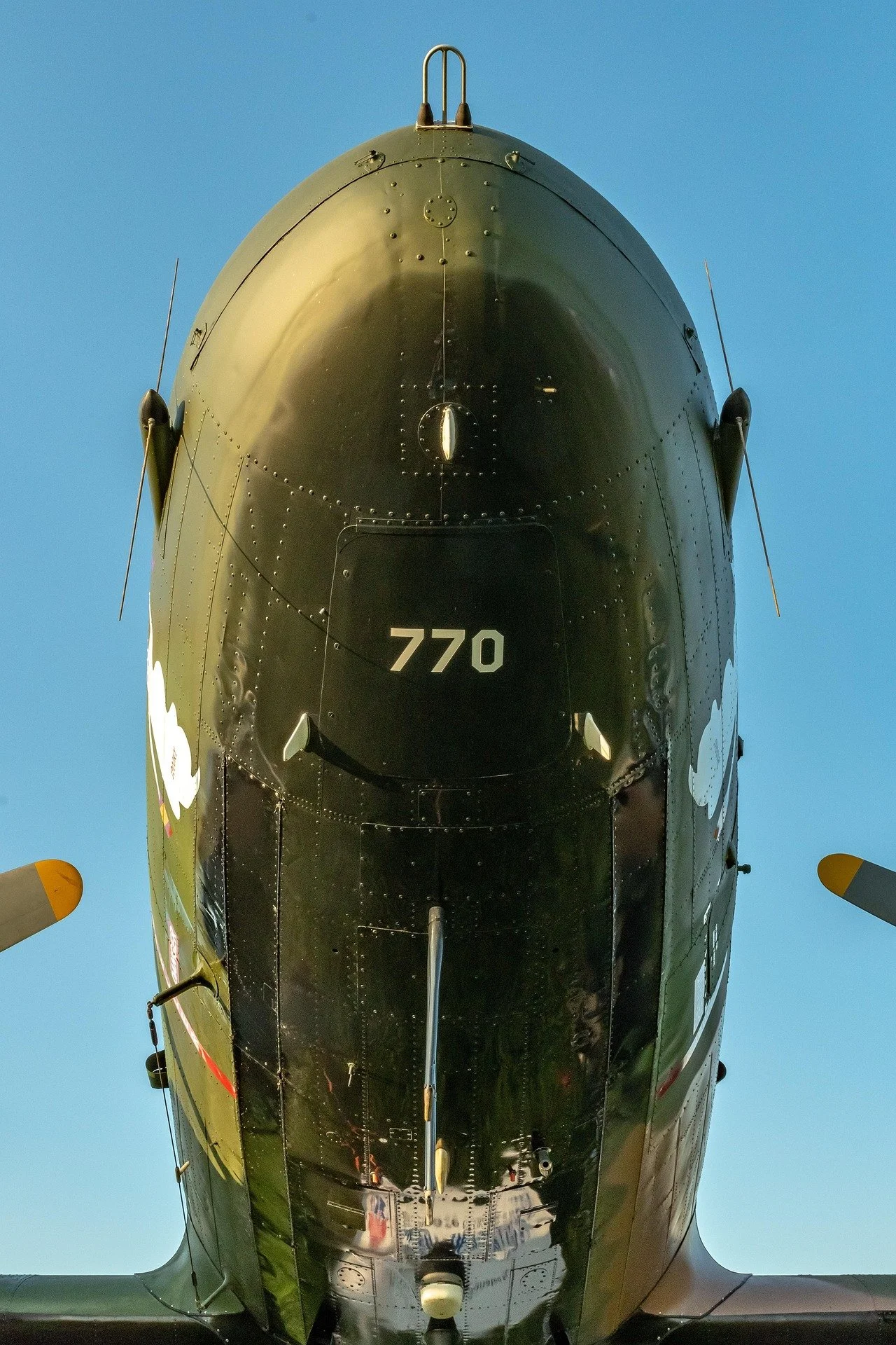 Front view of a black military aircraft with the number 770 on its nose, against a clear blue sky.
