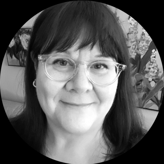 A woman with dark hair, wearing glasses, smiling in a close-up portrait with floral artwork in the background.