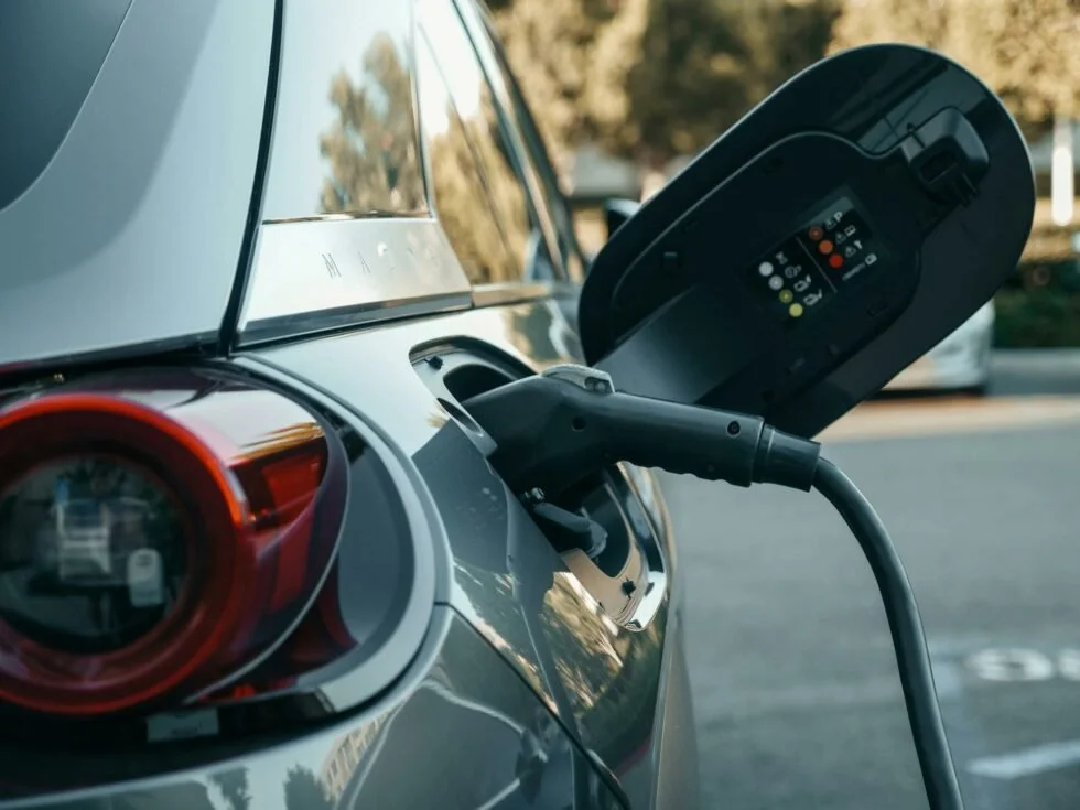 Une voiture électrique en train d'être rechargée par une borne de recharge