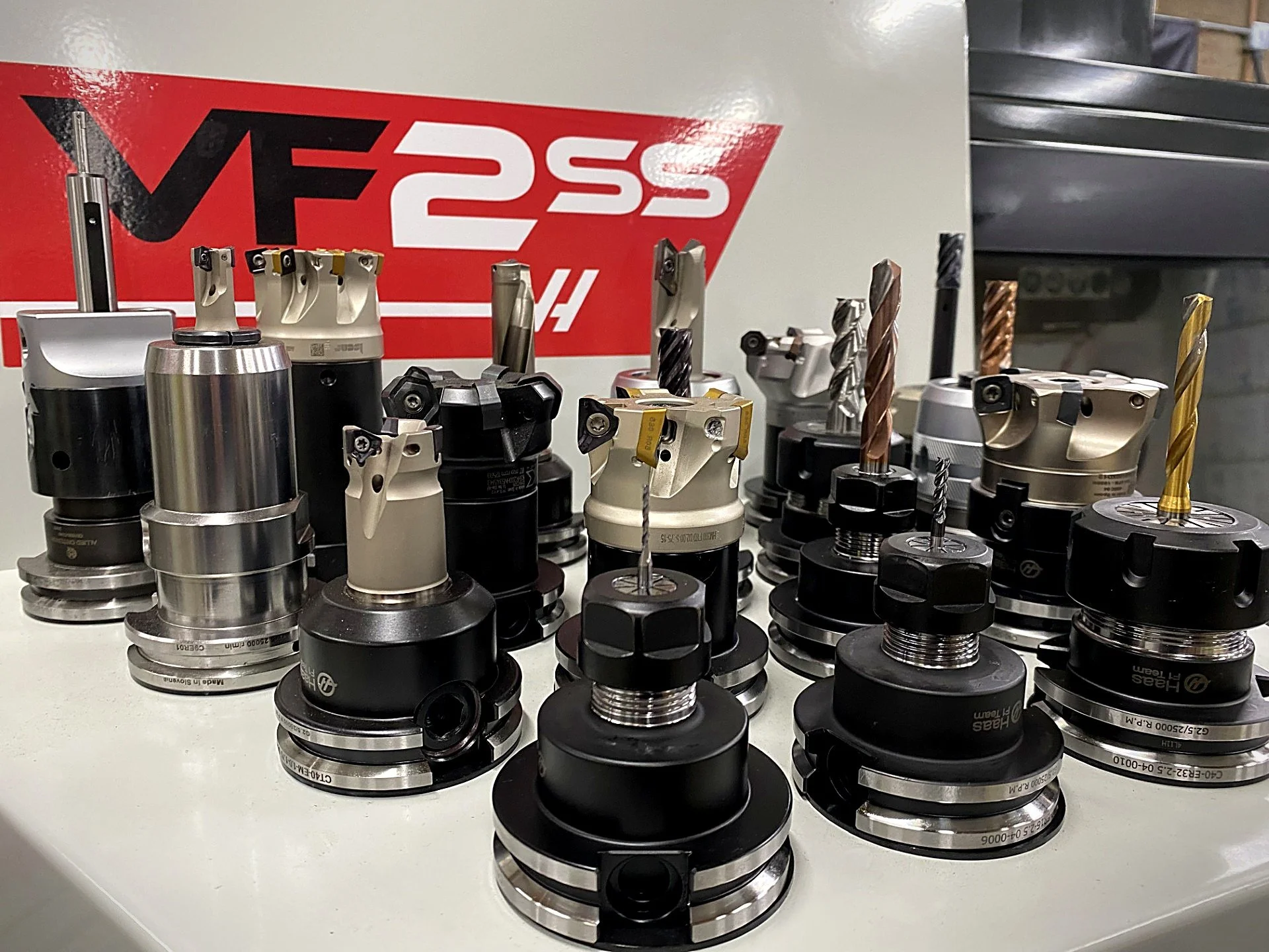 CNC tool holders and cutters in front of a Haas VF2SS