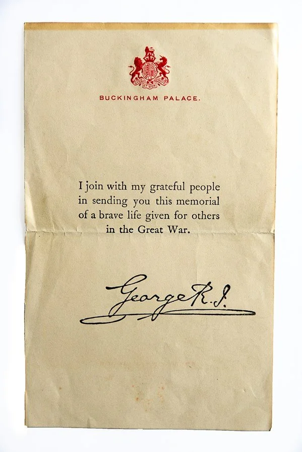 A vintage memorial letter from Buckingham Palace with a red royal crest at the top, expressing gratitude for a brave life given in the Great War, signed by George R. I.