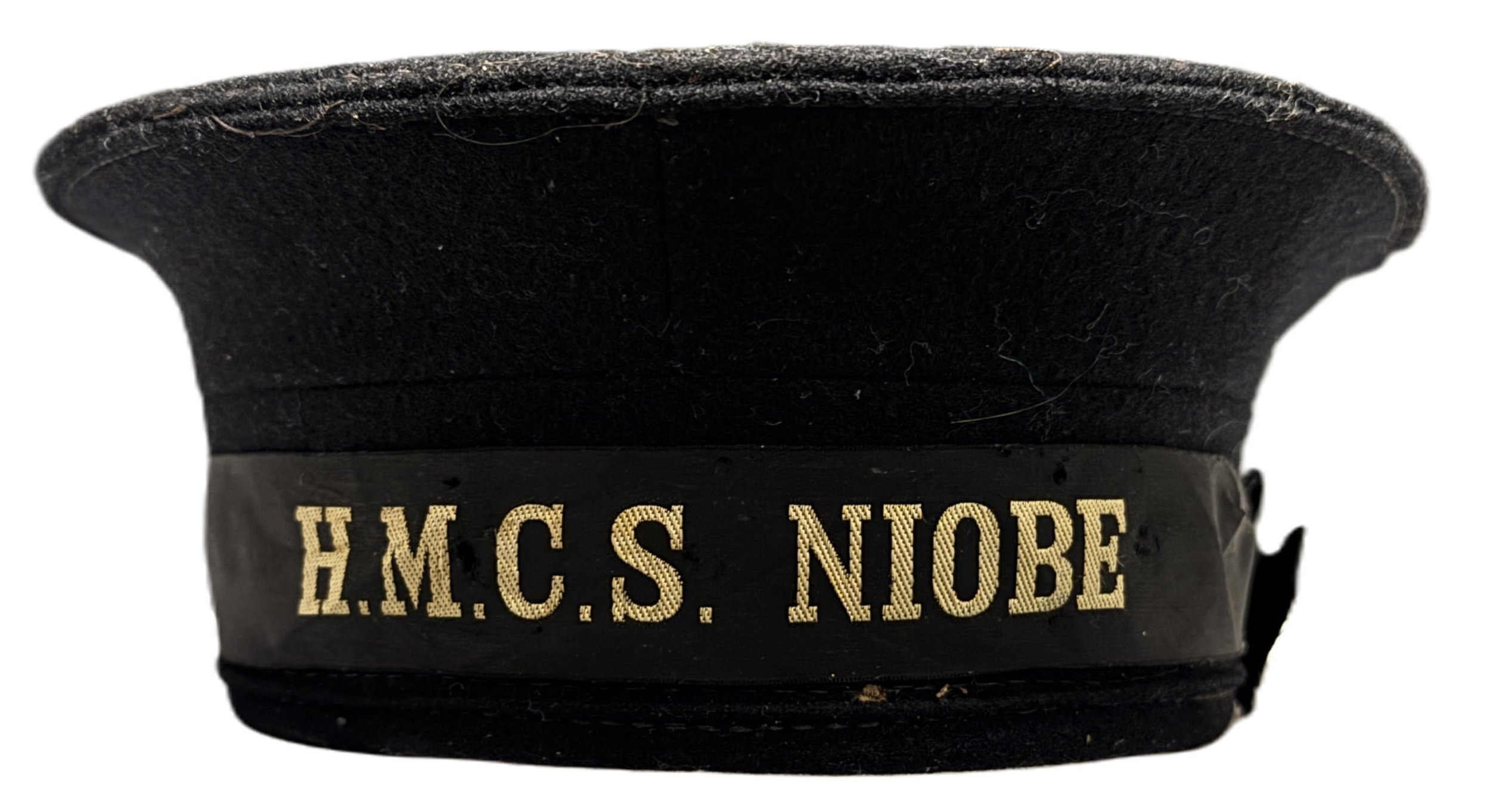 Black military or police hat with a black band that has gold embroidery reading 