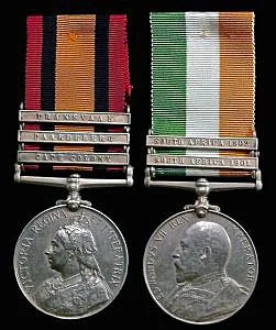 Two military medals with ribbons, displayed above their corresponding round silver medals featuring portraits of military personnel, against a black background.