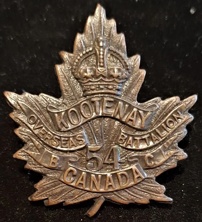 Historical Canadian maple leaf badge with crown, reading 'Kootenay' and '54 C'.