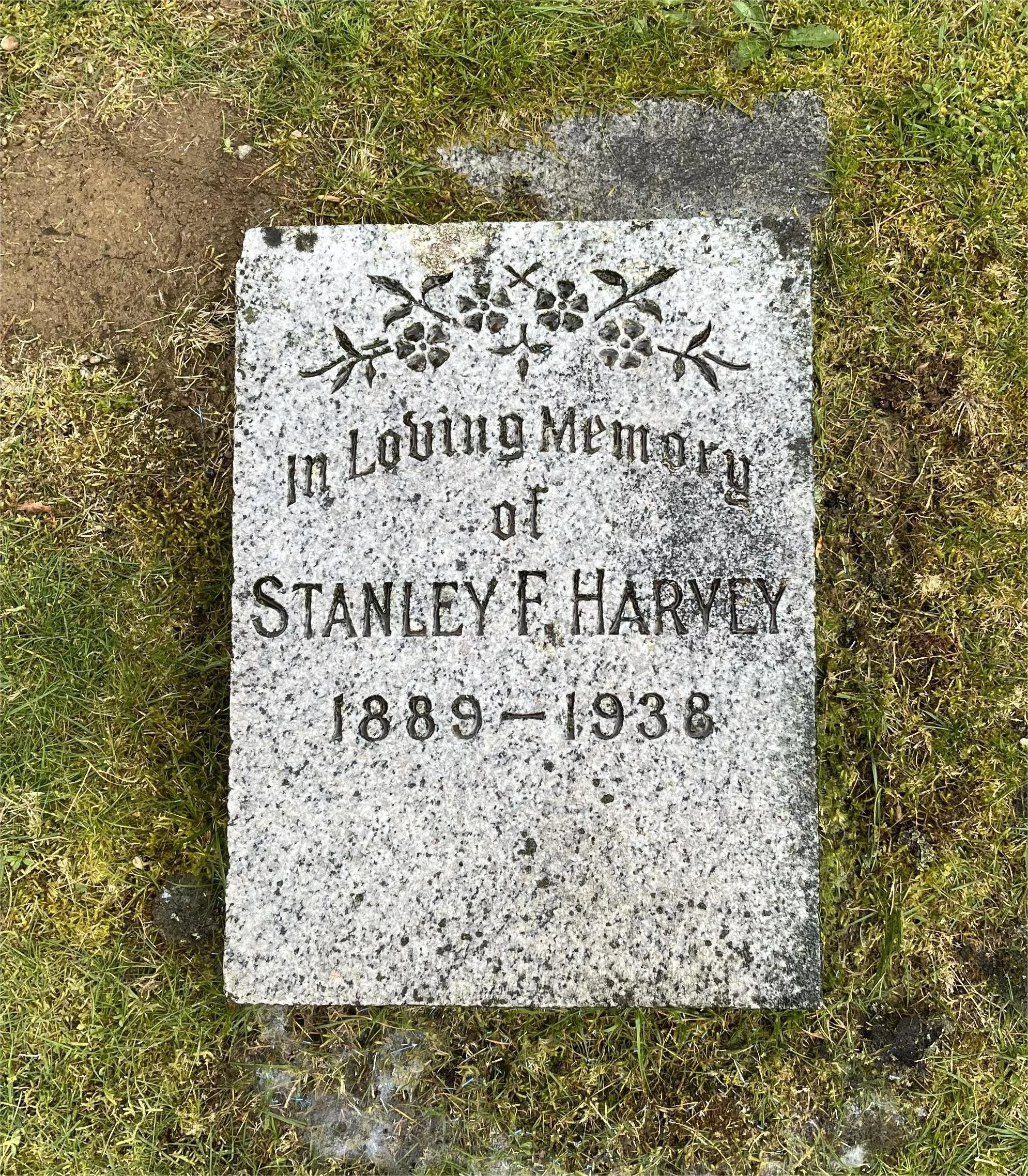 Gravestone with engraved floral design, inscribed with 'In Loving Memory of Stanley F. Harley 1889-1938'.