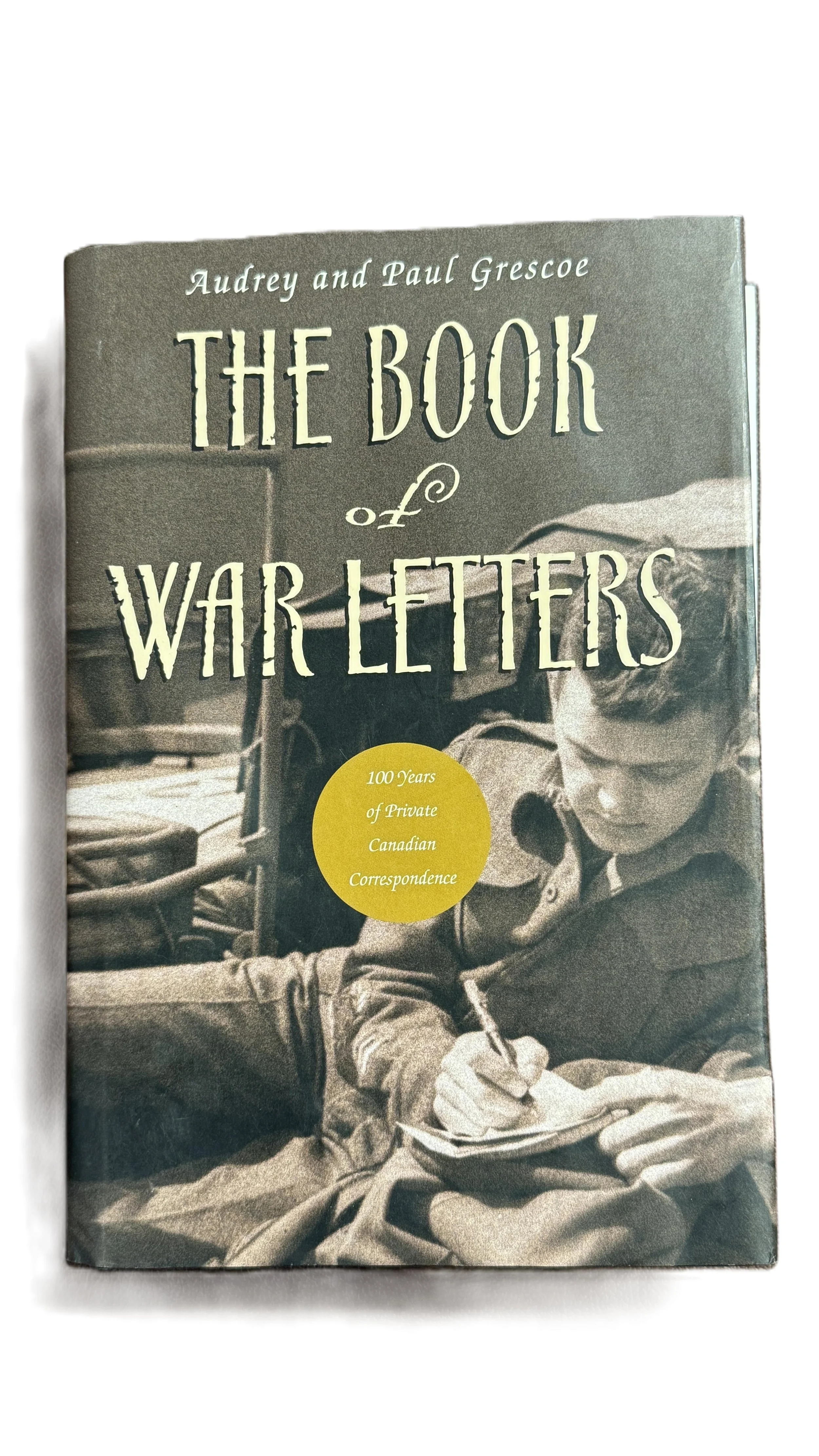 Book titled 'The Book of War Letters' by Audrey and Paul Grescoe, featuring a black-and-white cover image of a woman writing in a notebook.