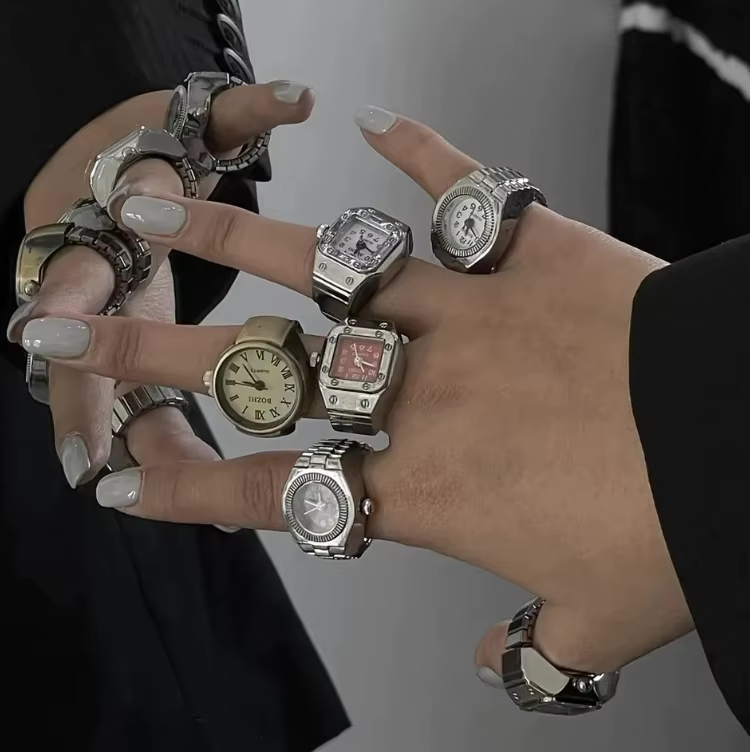 A woman’s hands display a striking collection of TinyTime ring watches including Pixie, Tinker, and Poem styles. With gold and silver bands, square and round faces, and vintage Roman numerals, this image is perfect for fashion-forward watch lovers an