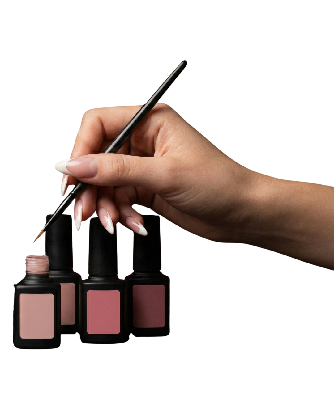 Close-up of a hand holding a brush and applying nail polish to three bottles of pink and red nail polish.