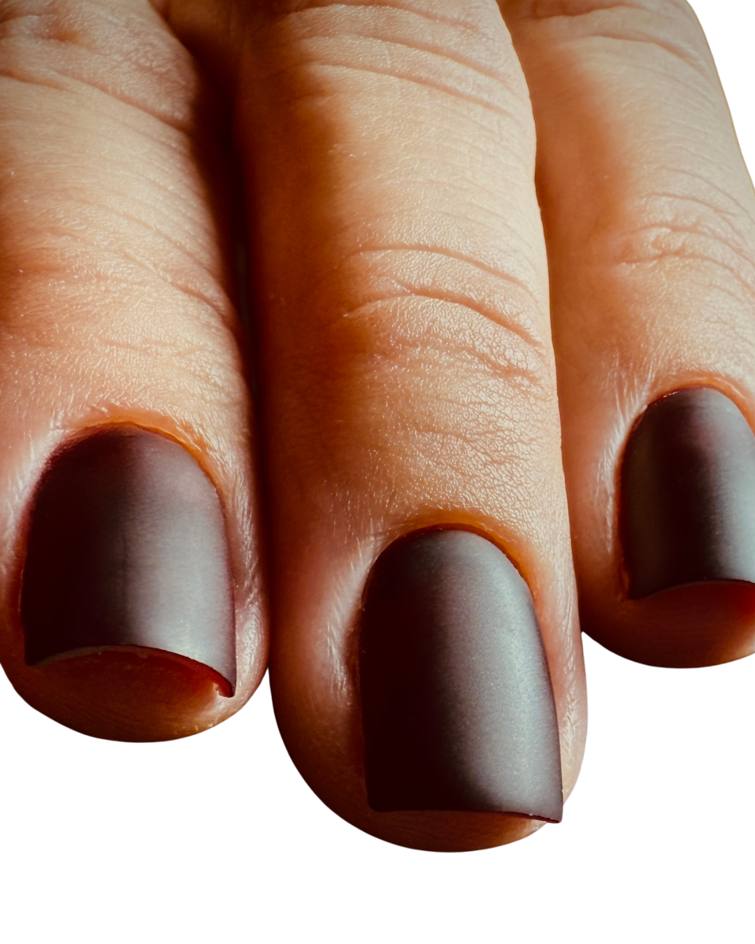 Close-up of a hand with fingernails painted deep red, showing 3 fingers with a Russian manicure.