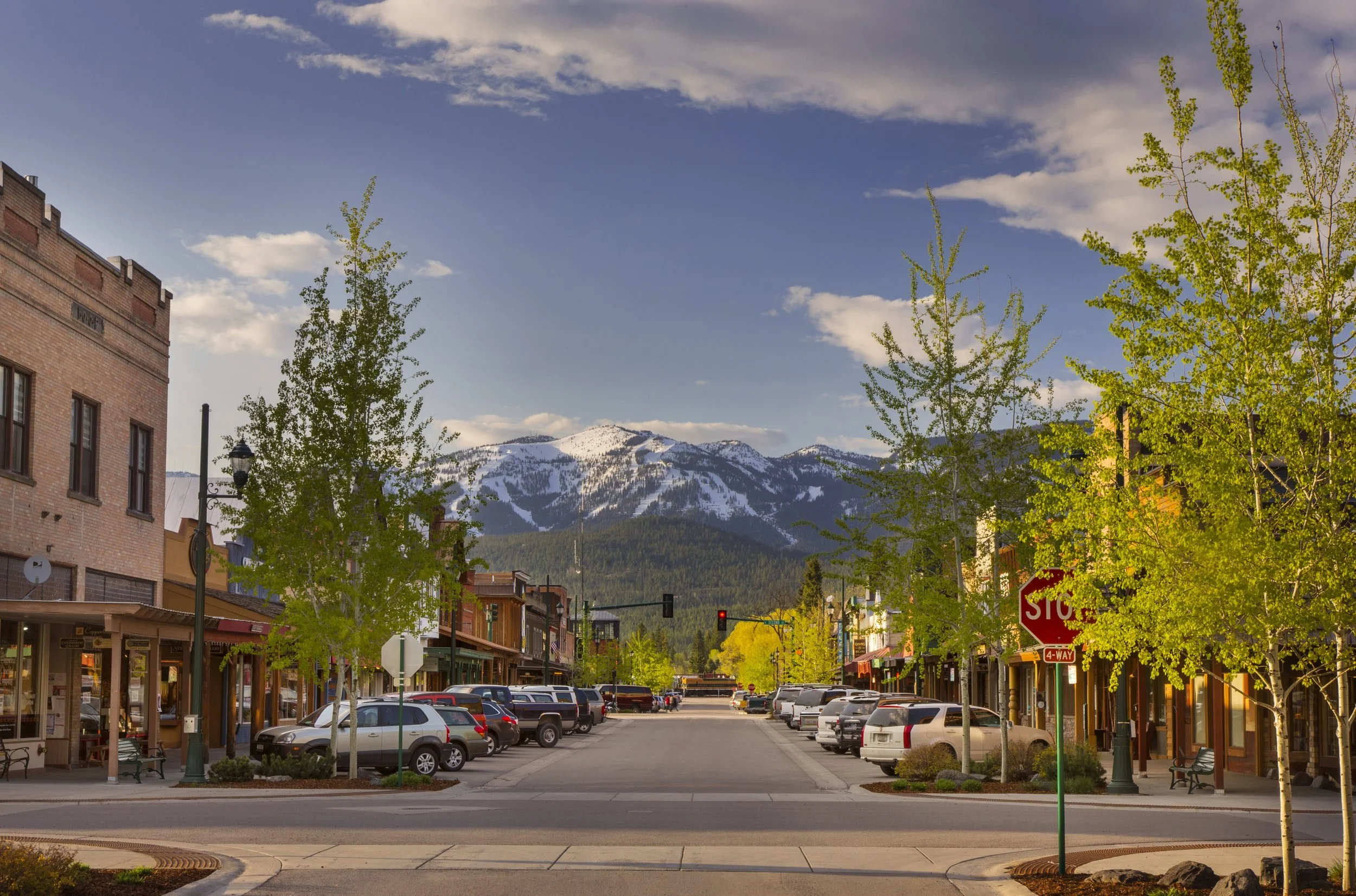 Whitefish's Central Avenue in the spring, with a snowy Big Mountain in the distance.