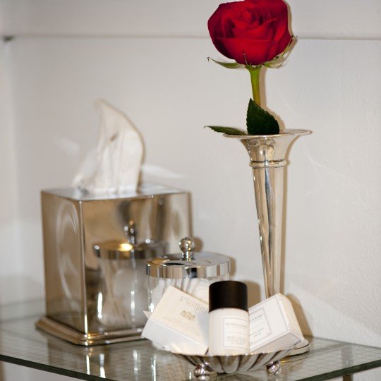Luxury bath amenities and a real rose in a sterling vase add to the experience
