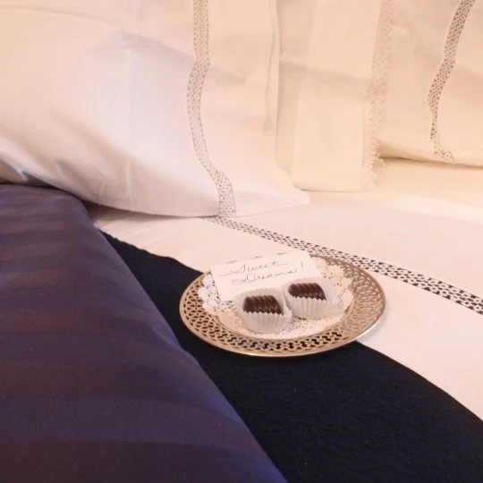 Evening turndown service with locally made chocolates and a note saying 'Sweet Dreams!'.