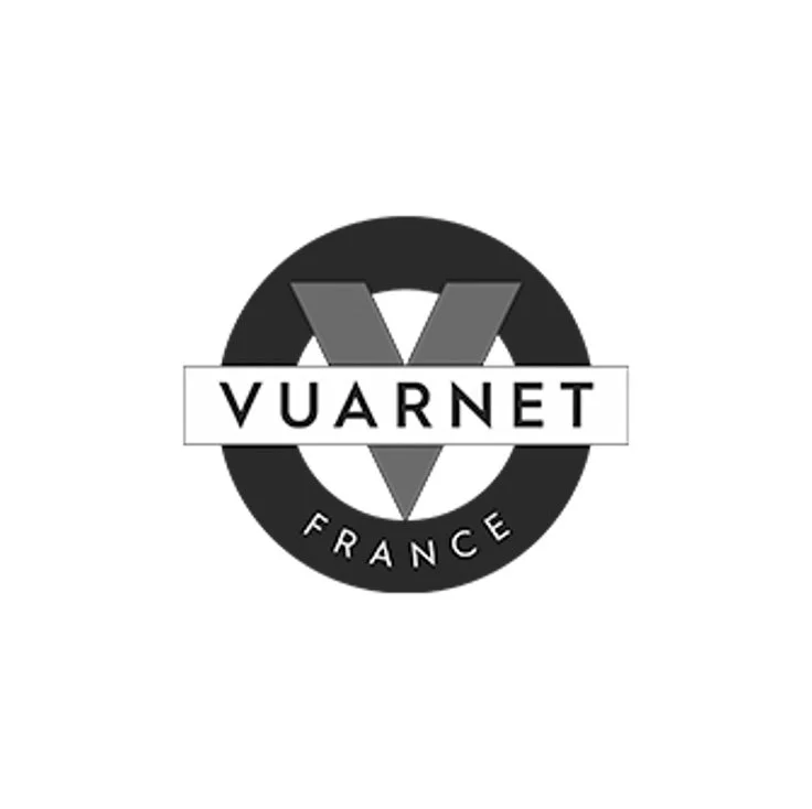 Logo noir et blanc avec un cercle, une grande lettre V au centre, le nom 'VUARNET' en barre horizontale à travers le cercle, et 'FRANCE' en arc en dessous.