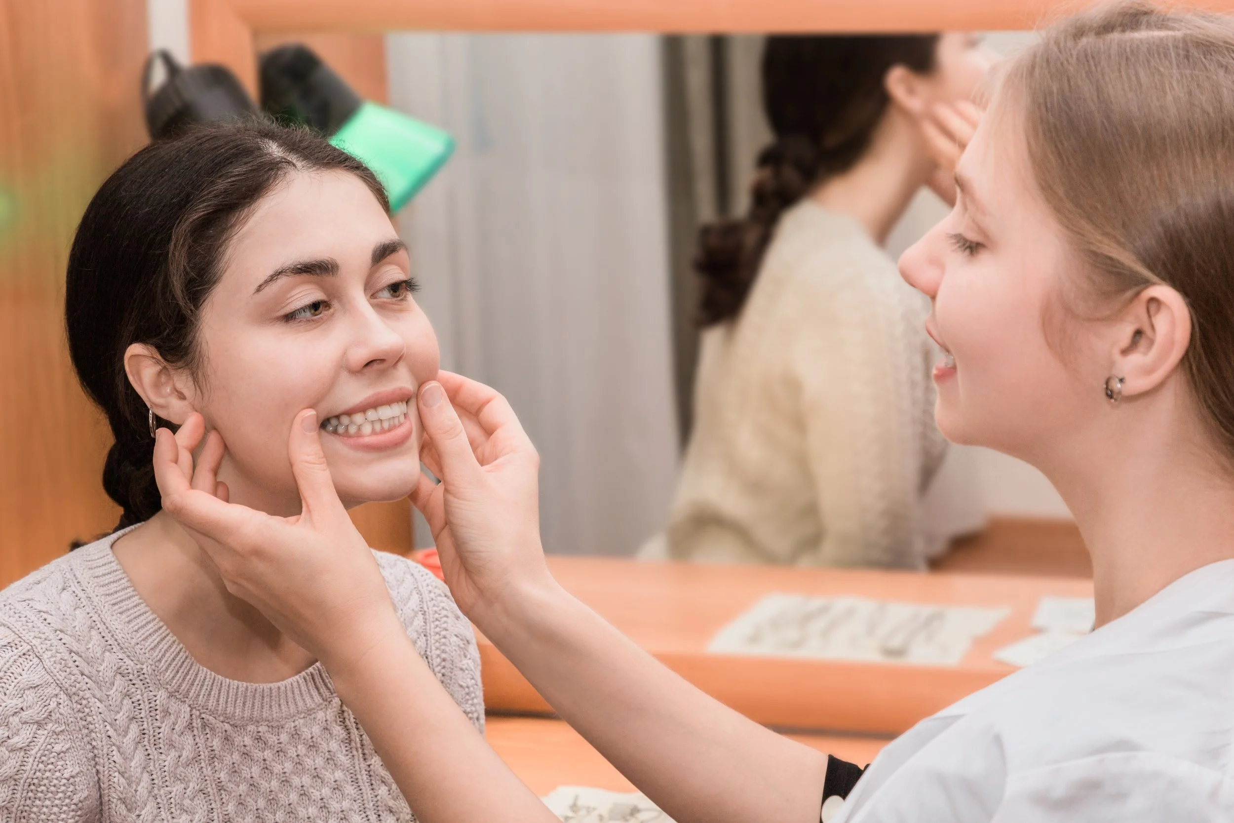A young woman with a dental professionals examining her teeth in a clinic.