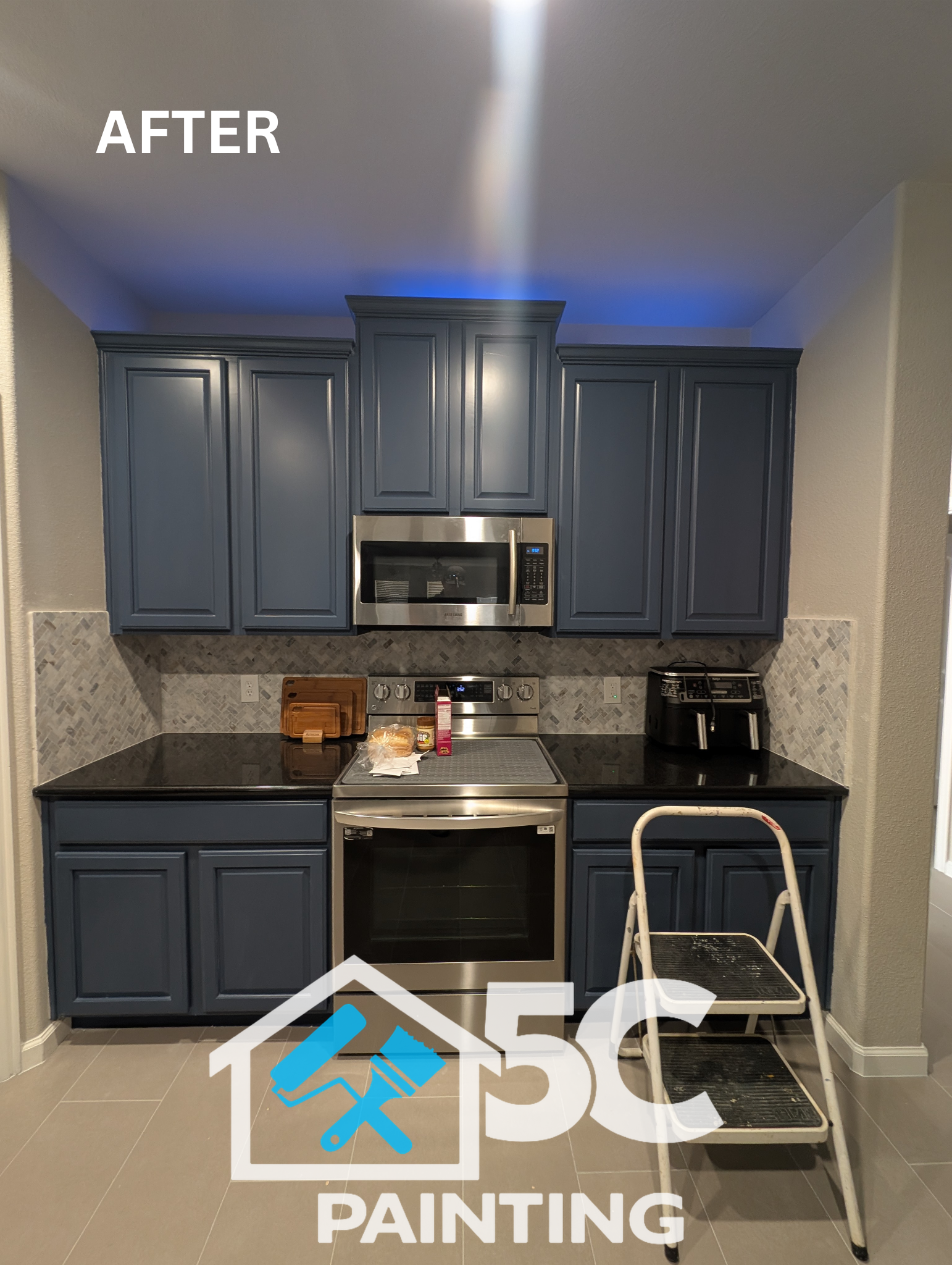 Cherry wood cabinets get new life with a professional slate blue repaint in this Lake Dallas kitchen. Clean, even coverage and crisp panel lines show the difference a quality cabinet paint job makes against black granite countertops.