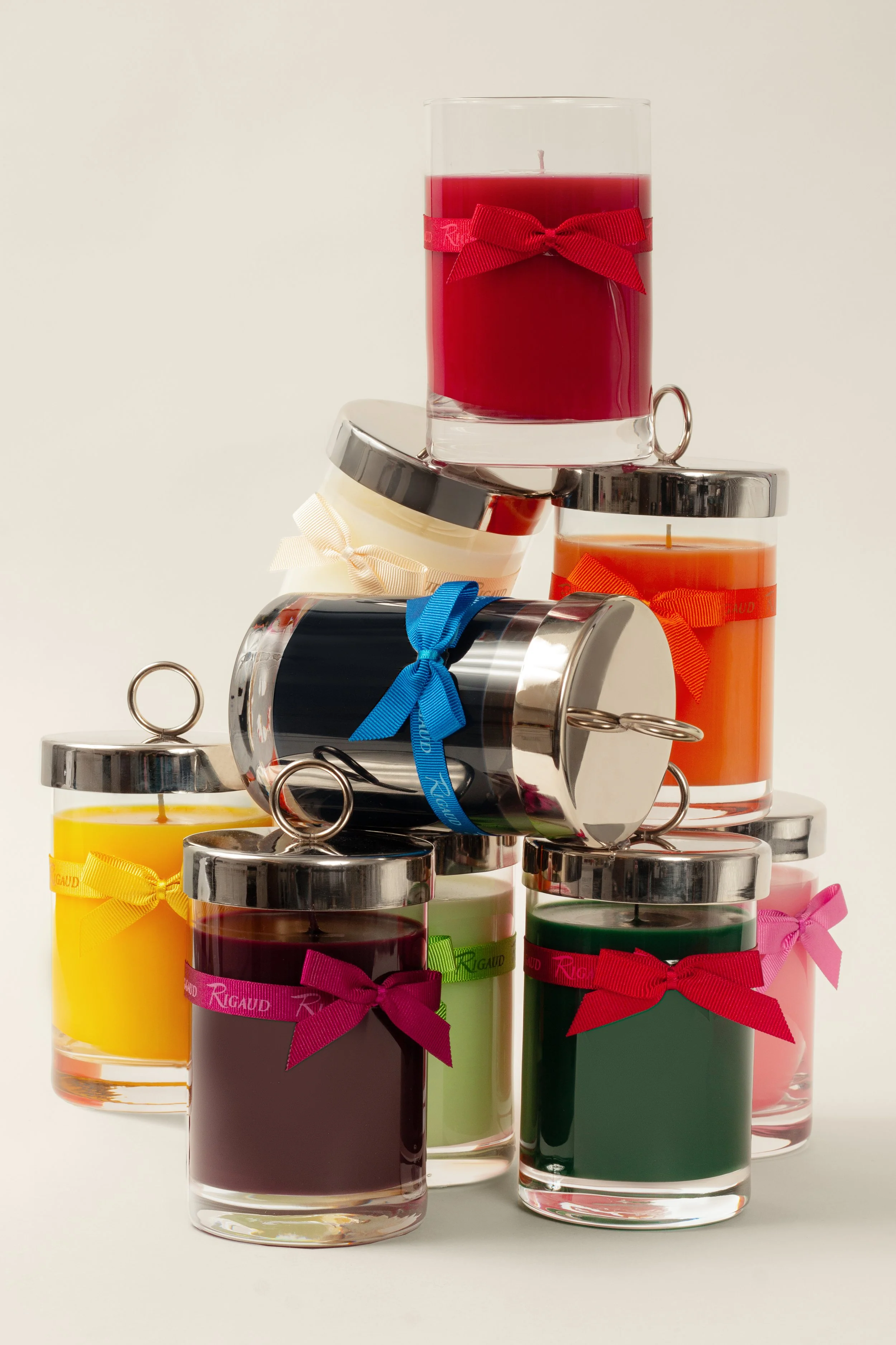 Nine glass candle votives, each wrapped with bright, colorful bows.