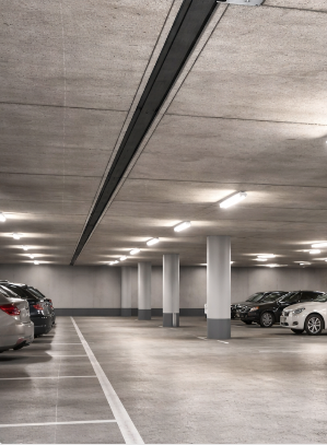 Innenaufnahme eines Parkhauses mit geparkten Autos und Betonbalken