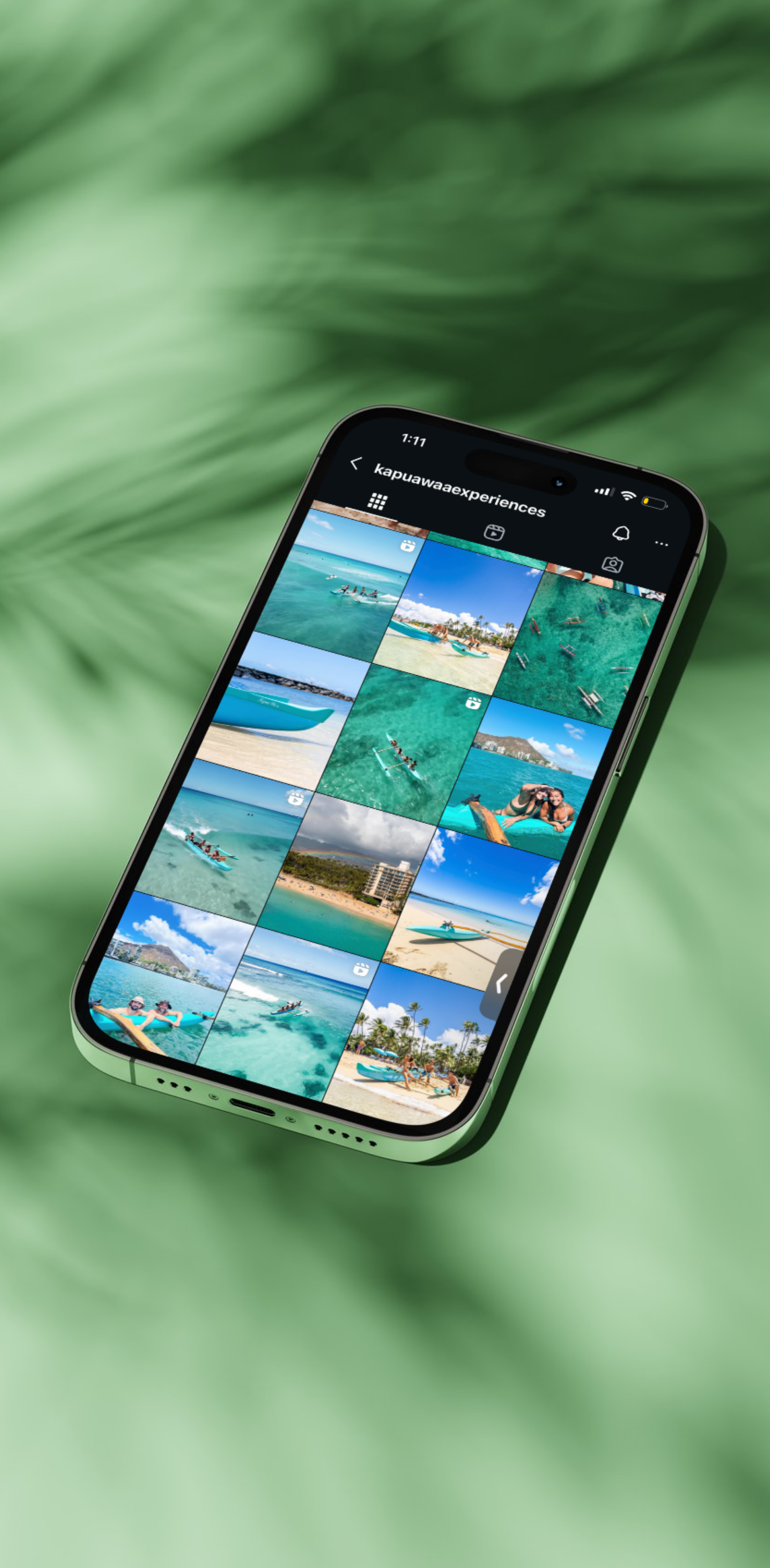 Smartphone displaying a photo gallery of beach and water activities on a green surface.