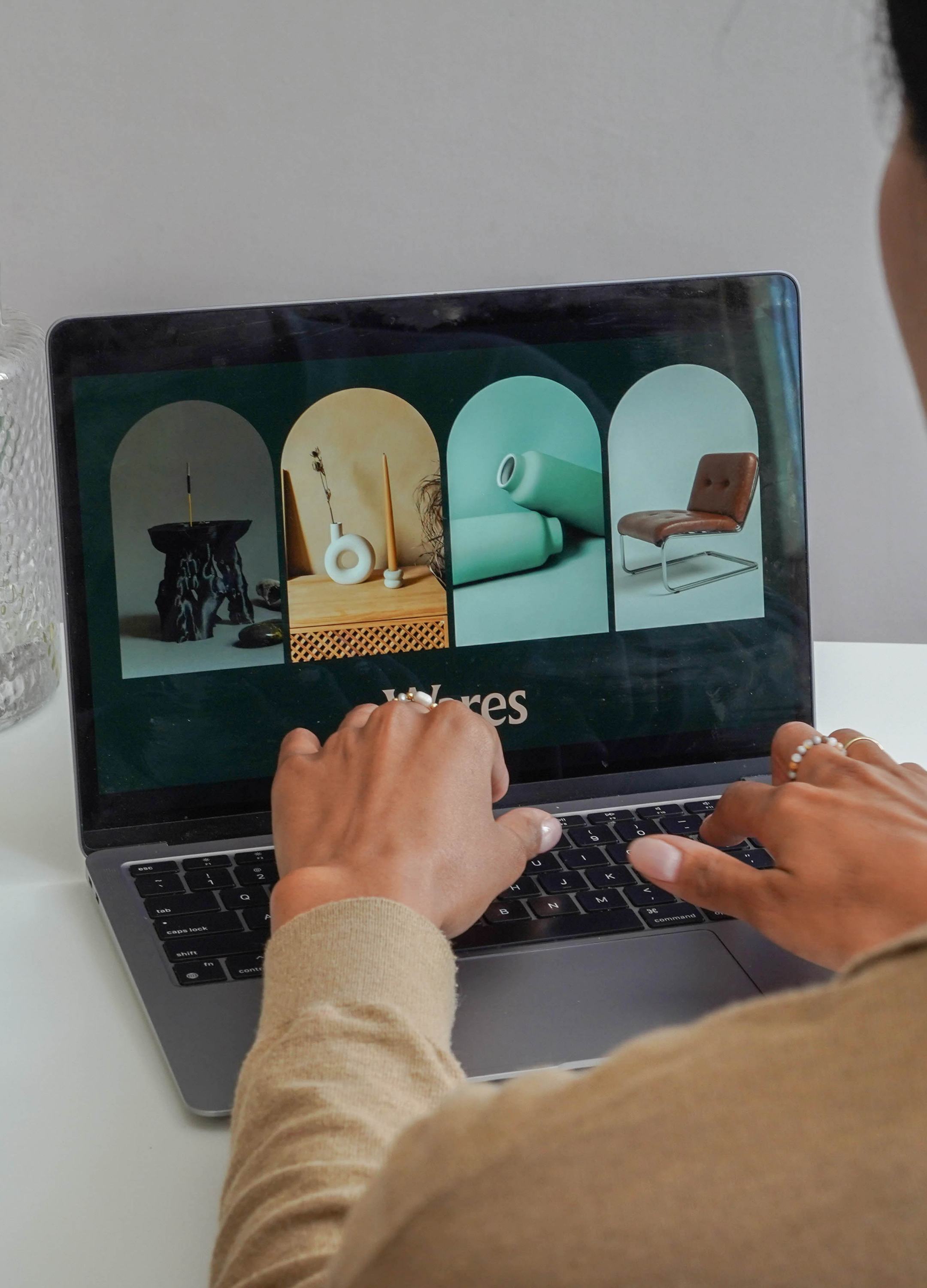 Person browsing an online furniture store on a laptop, showcasing various modern home decor items and furniture.