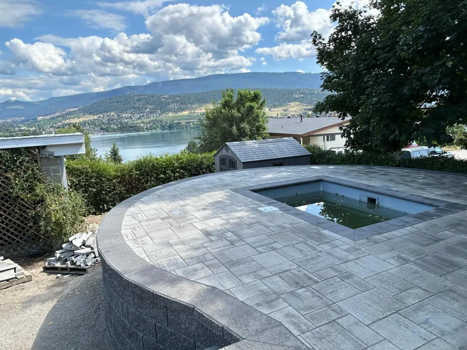 A hot tub built into a raised backyard patio that was designed and installed by Peacock Landscaping, Vernon, BC.