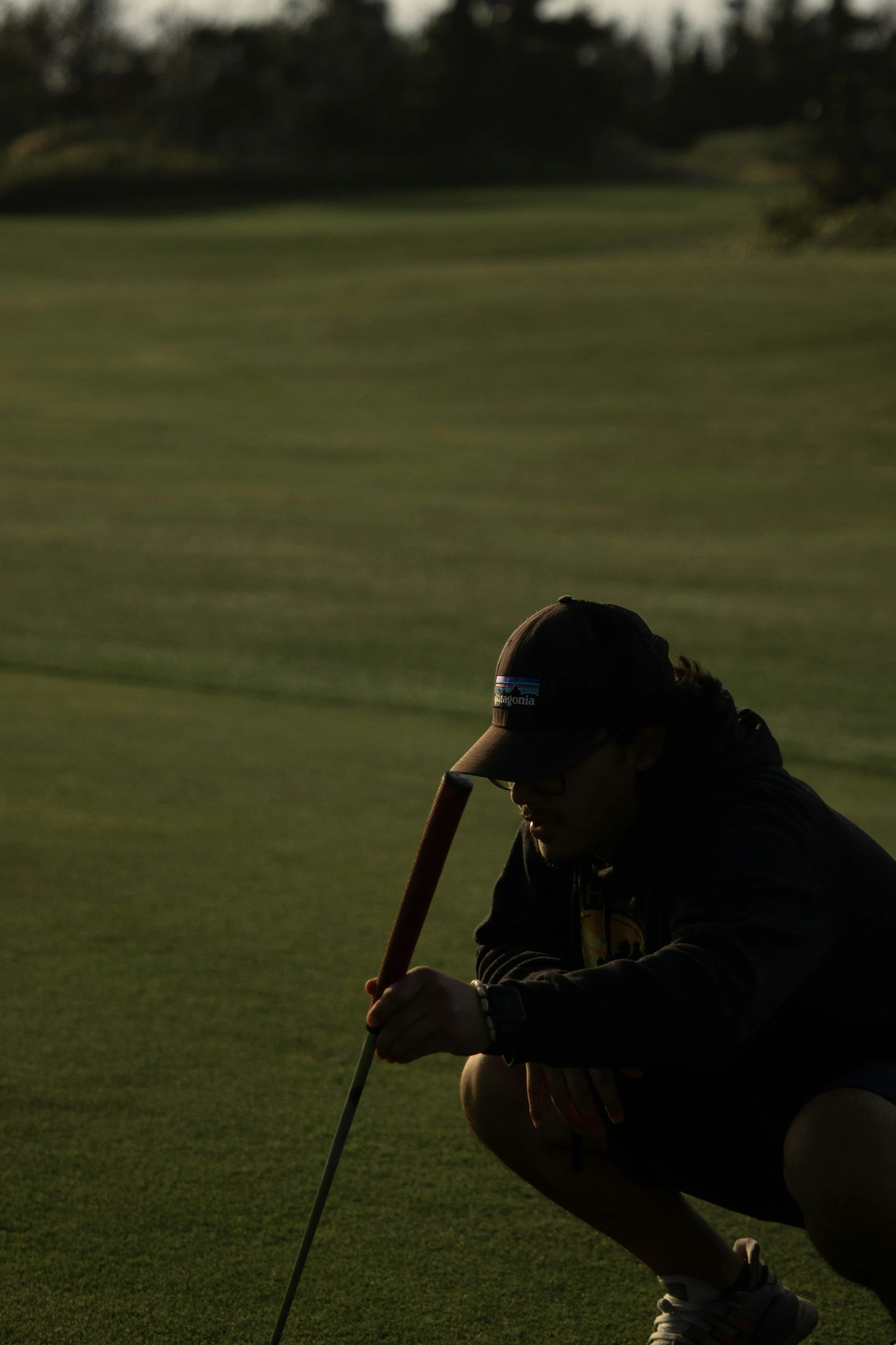A golf ball balanced atop a red tee against a black background.