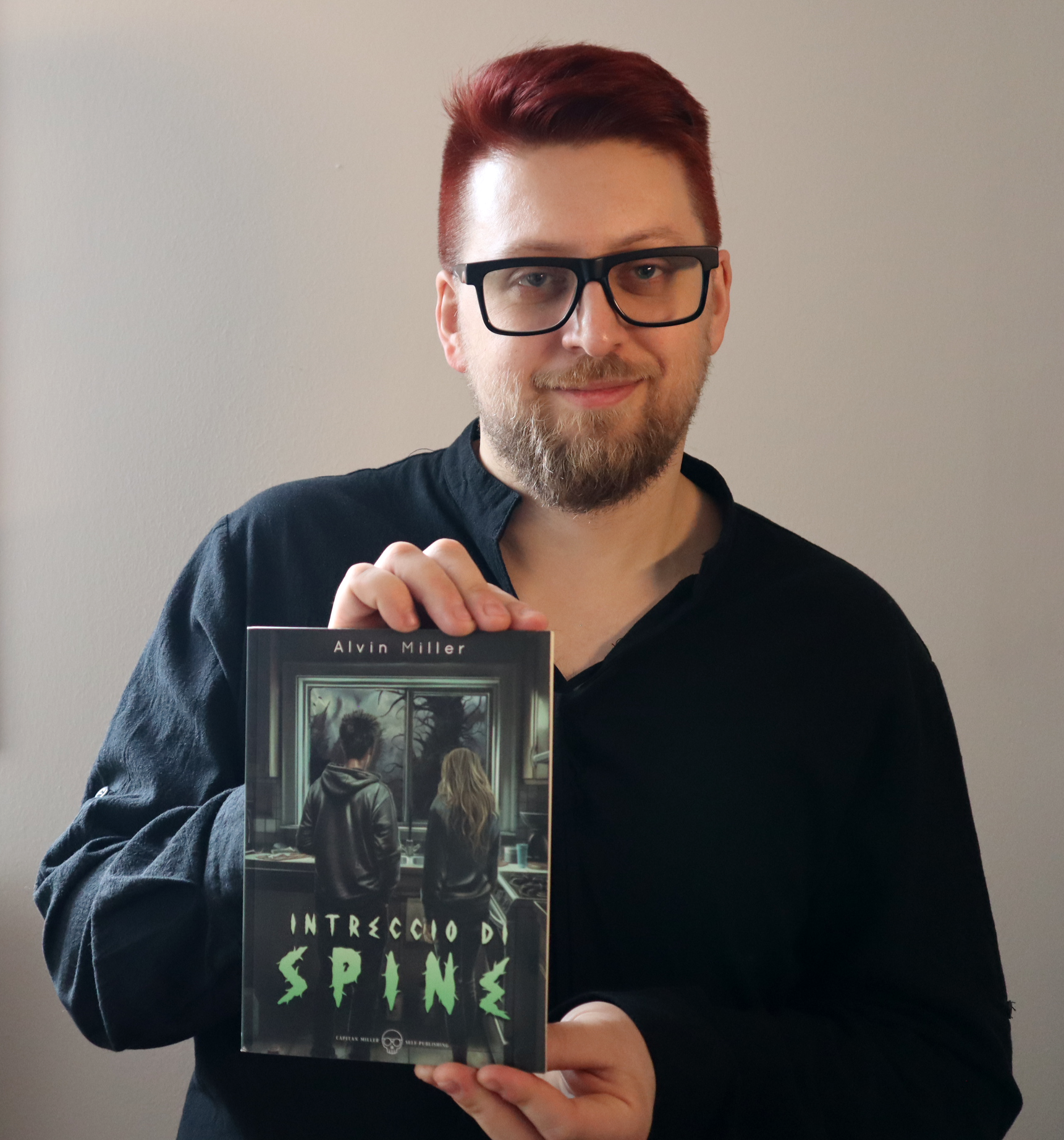 Alvin Miller con in mano una copia del suo libro: Intreccio di Spine.
