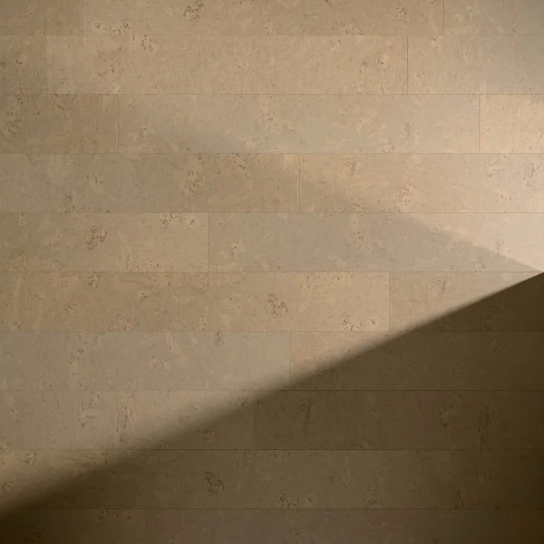 Close-up of beige tiled floor with a shadow cast diagonally across the surface. Flooring at Okanagan Hardwood Flooring Kelowna BC