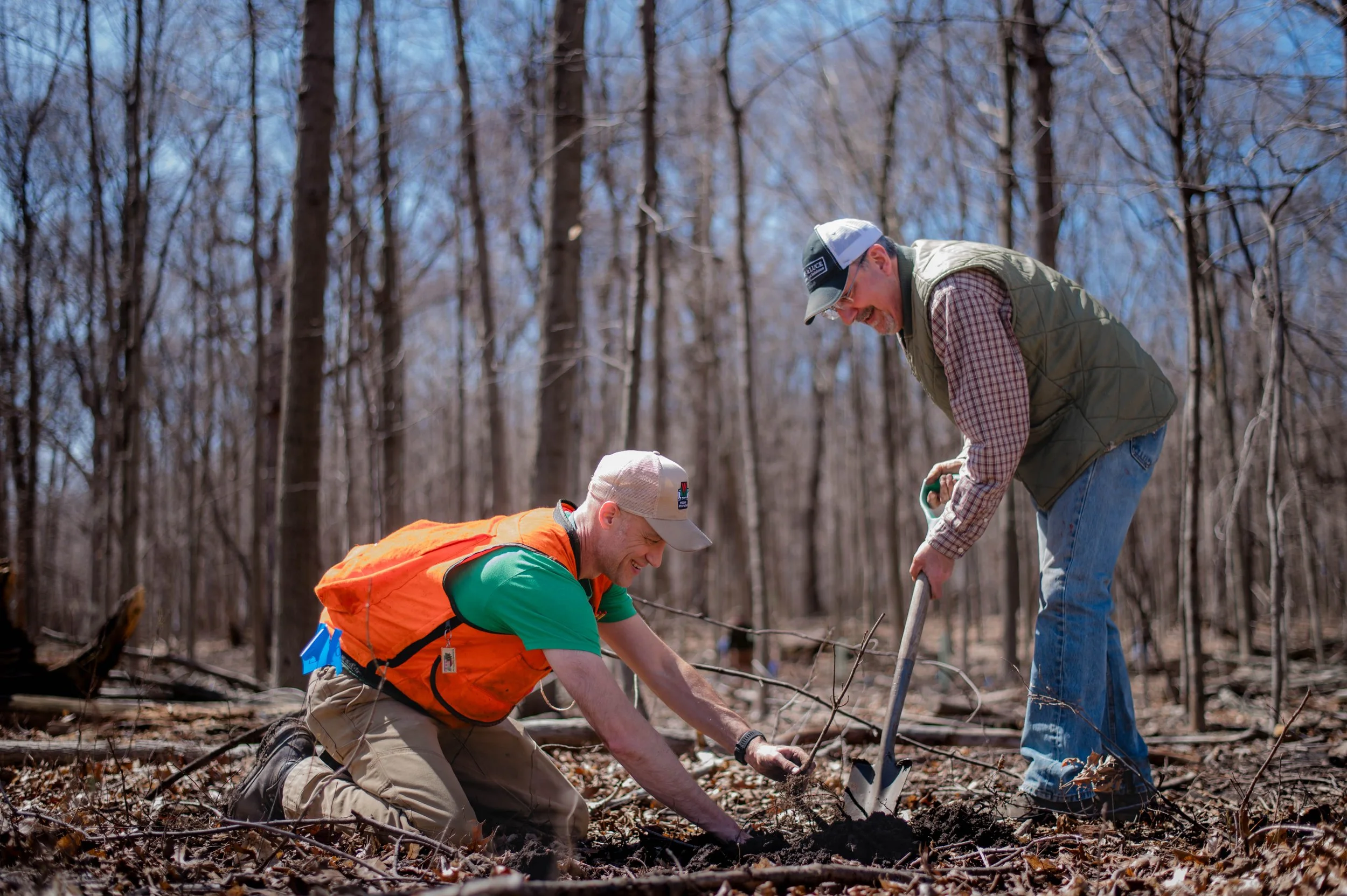 Eric Zenz (left) and Brad Hutnik (right) are planting a tree seedling at the Forest Exploration Center in April 2024