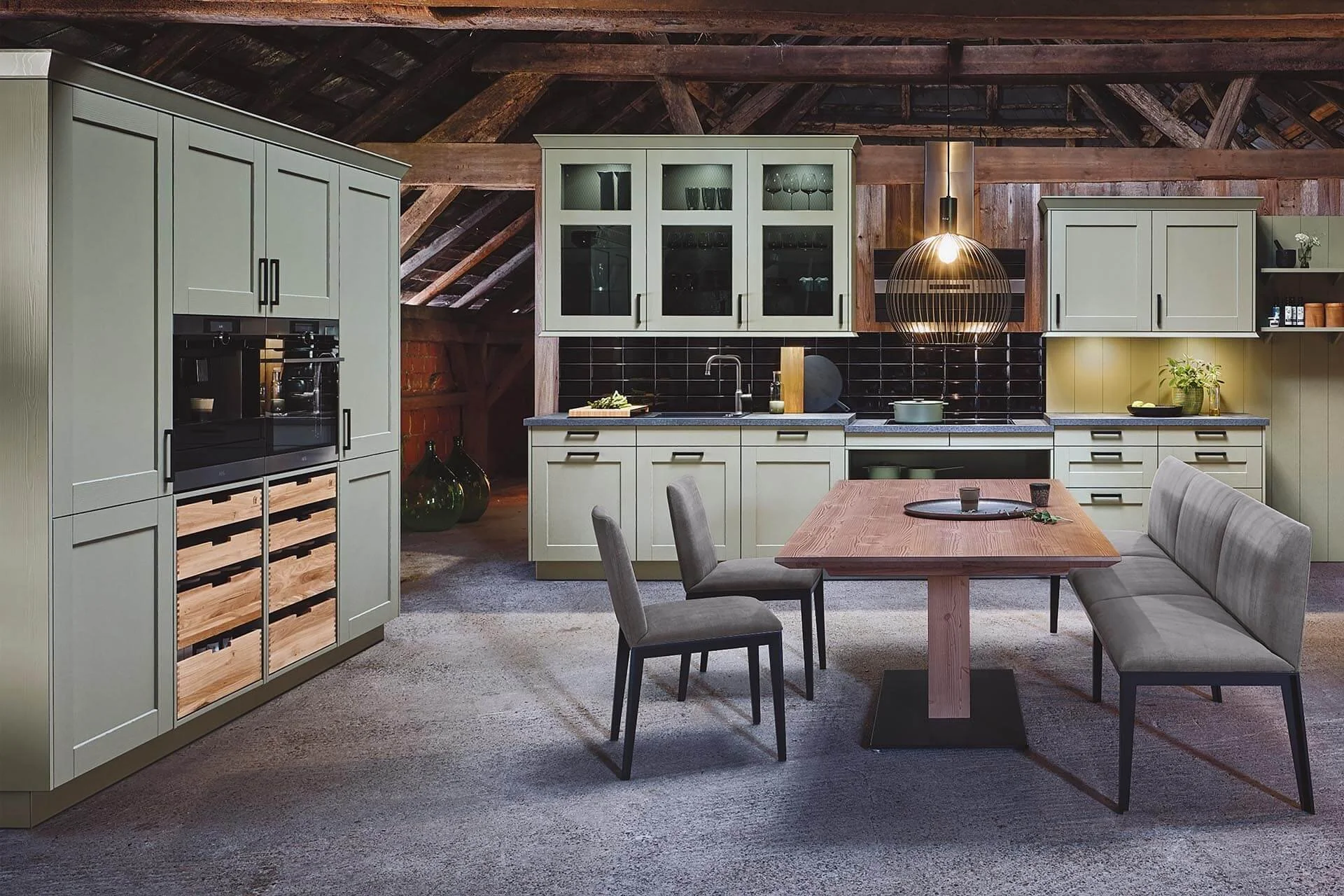 Moderne Landhausküche mit grünen Schränken, offener Essbereich, Holzdecke und schwarze Vintagefliesen. Küche mit Rahmenfronten und Glasschränken, moderne Essgruppe mit Tisch aus Massivholz