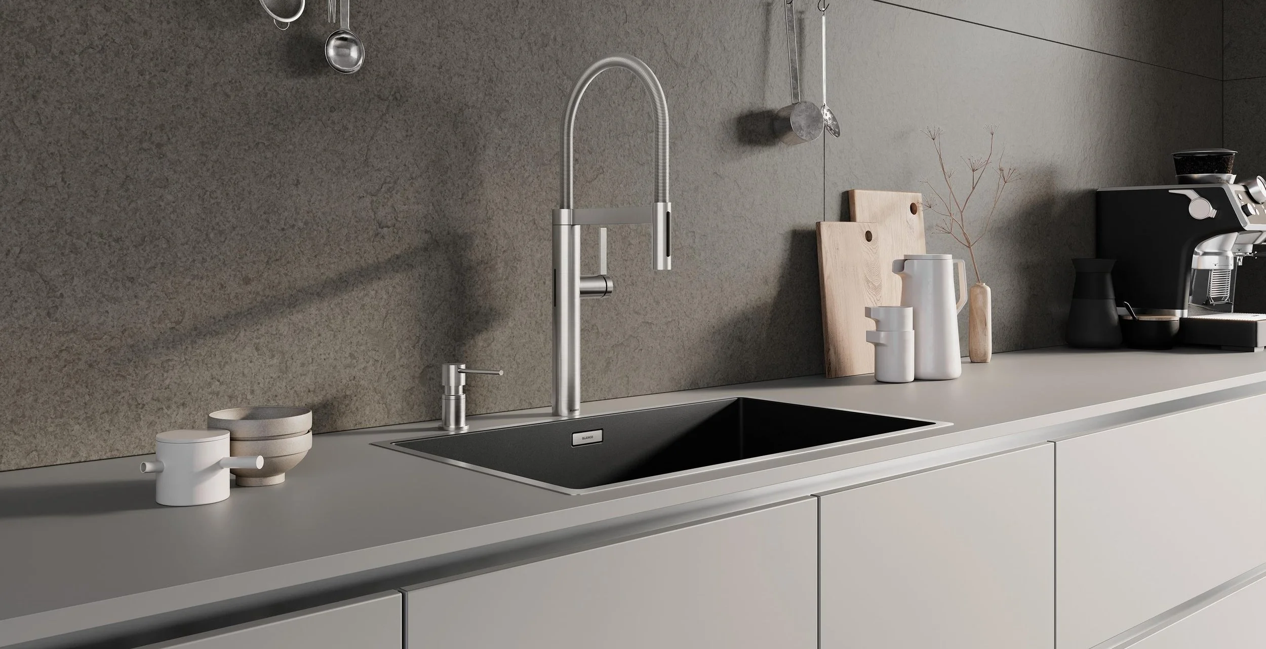 Moderne grifflose Küche mit Keramikarbeitsplatte, Edelstahlarmatur, schwarzen Spüle, weißen Kaffeekannen, Holzschneidebrettern und einer Kaffeemaschine.